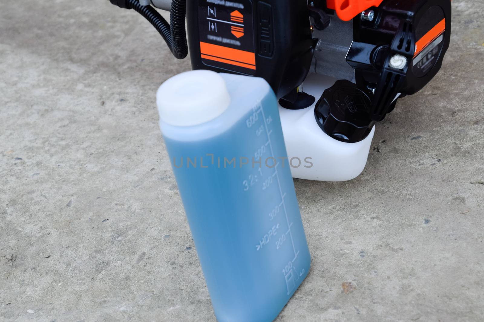 Prepared fuel mixture for a two stroke gasoline trimmer engine. Gasoline trimmer. Trimer gascosis with a leaf for mowing grass and shrubs.