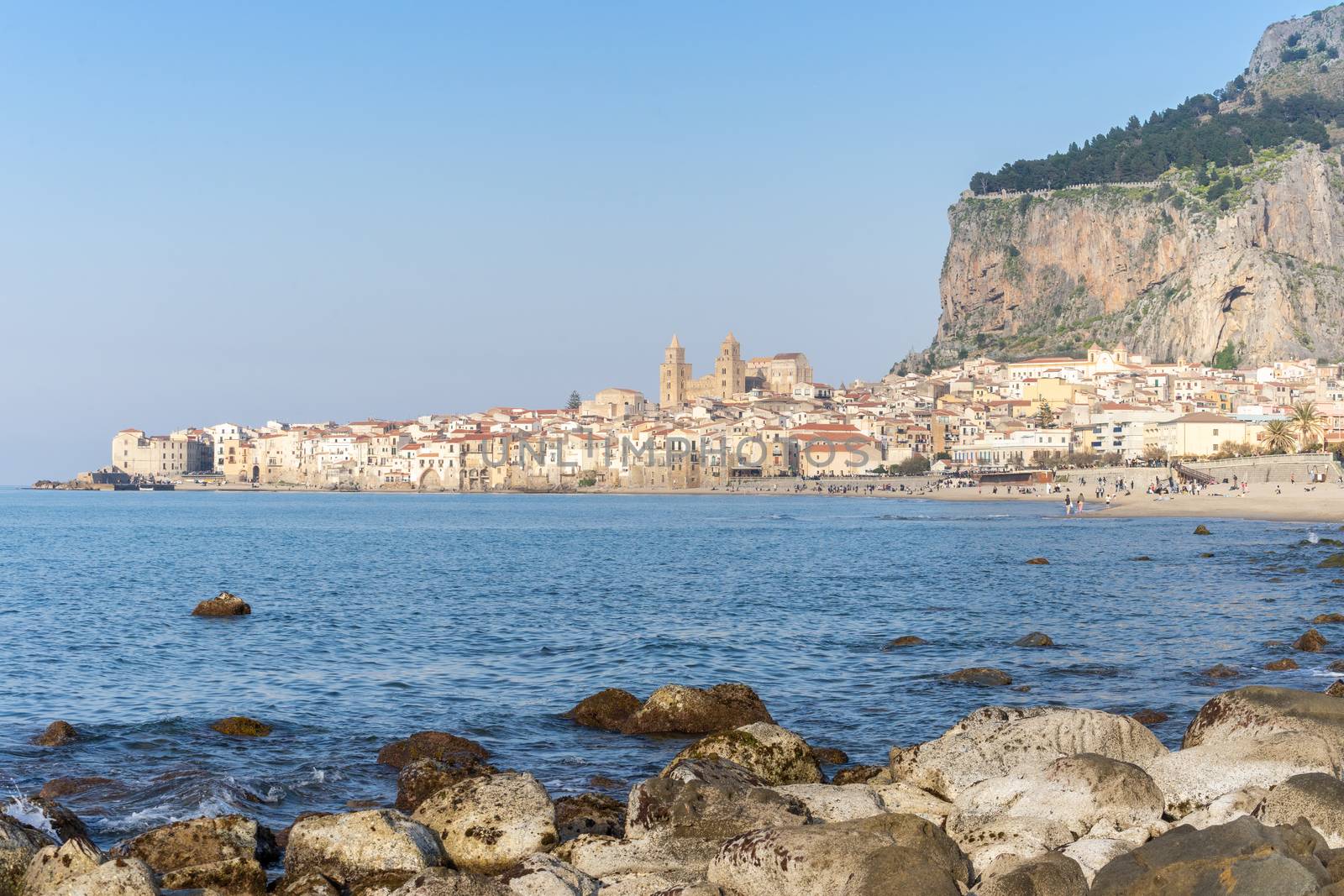 Idyllic view of Cefalu from the long sandy beach. Cathedral and Rocca di Cefalu rocky mountain on a sunny day in Cefalu, Sicily, Southern Italy. by tamas_gabor