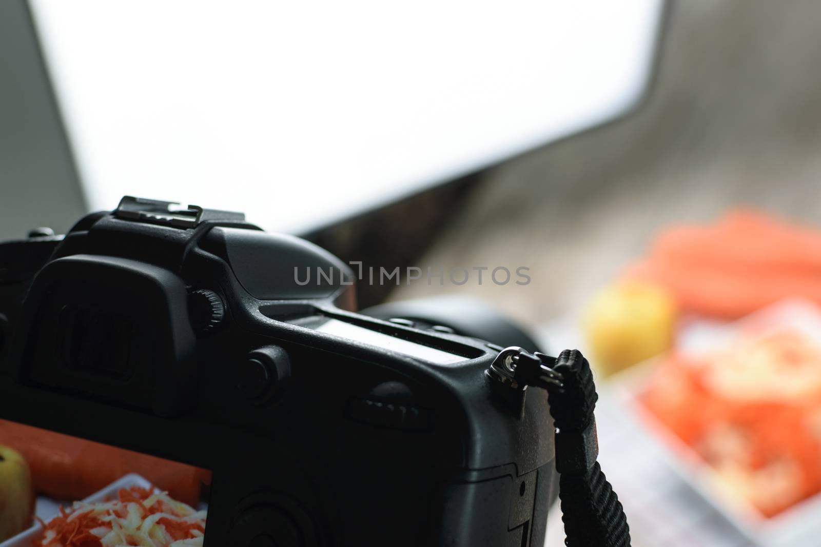 Concept image  -  rear view of DSLR camera making a food photography in the photo studio