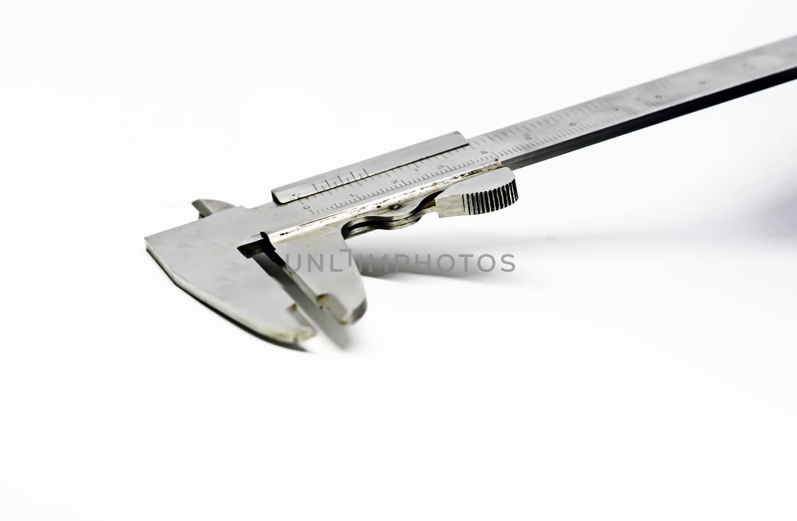 Detail view of a metallic caliper used to measure the distance between two opposite sides of an object. Engineering and construction industry. Isolated on a whote background
