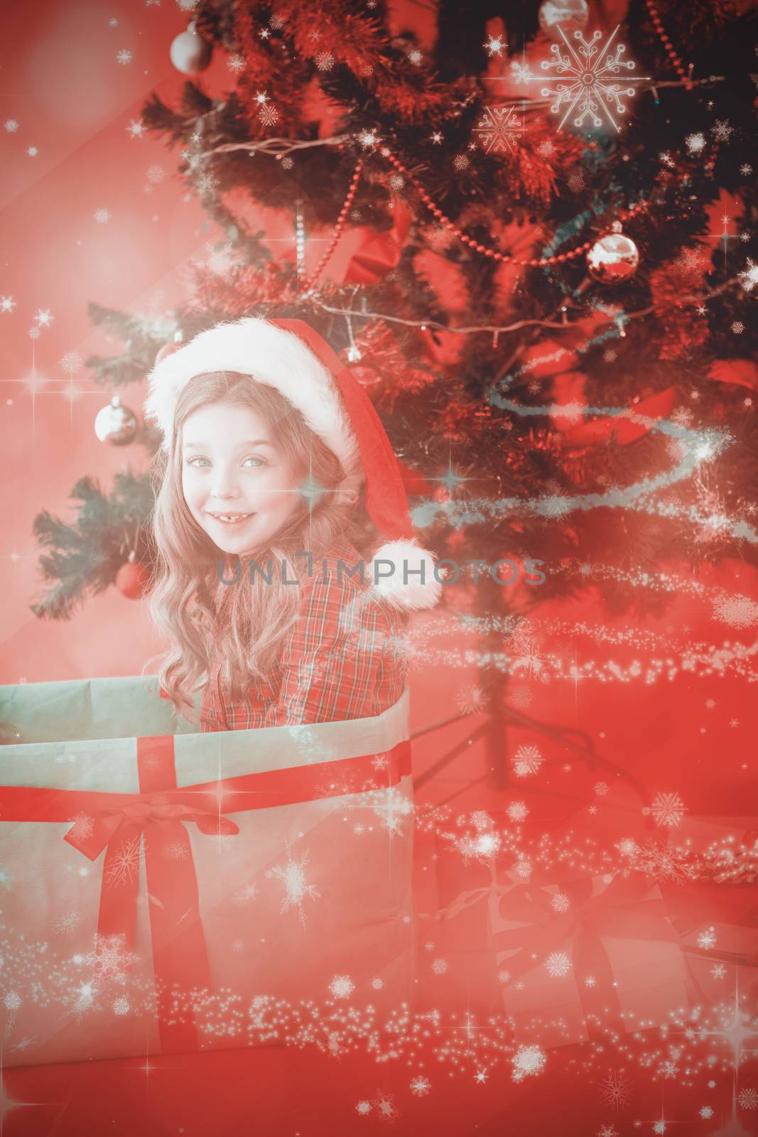 Festive little girl sitting in large gift against glittering christmas tree design