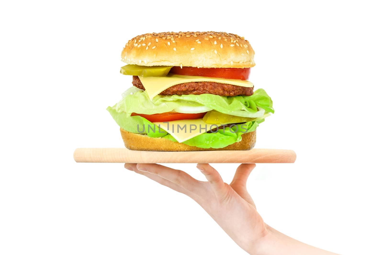 Concept of food serving service - female hand holding a wooden board with a big hamburger on a white background (mixed)
