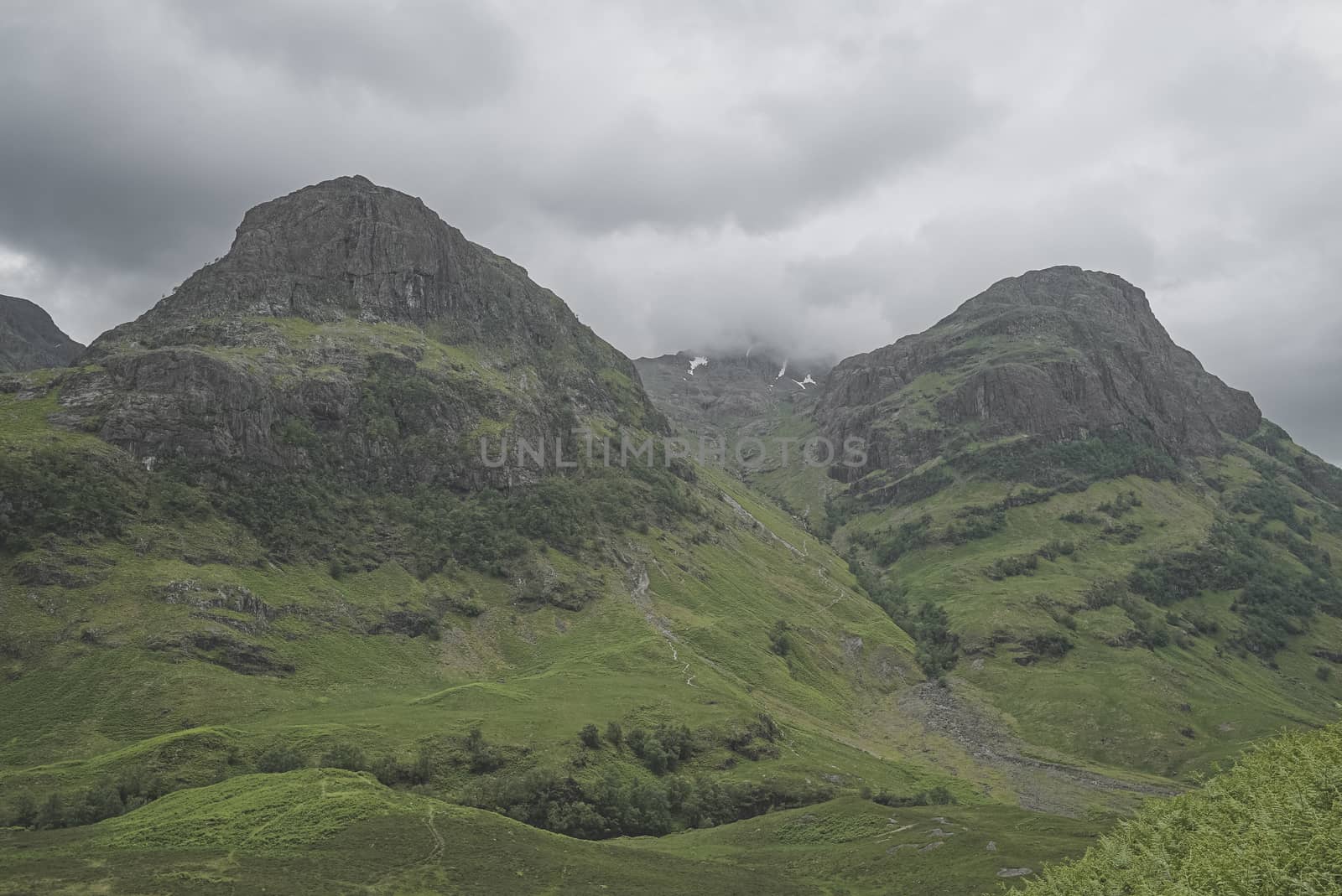 Landscape of nature in Scotland, three mountains with fog at top and no people