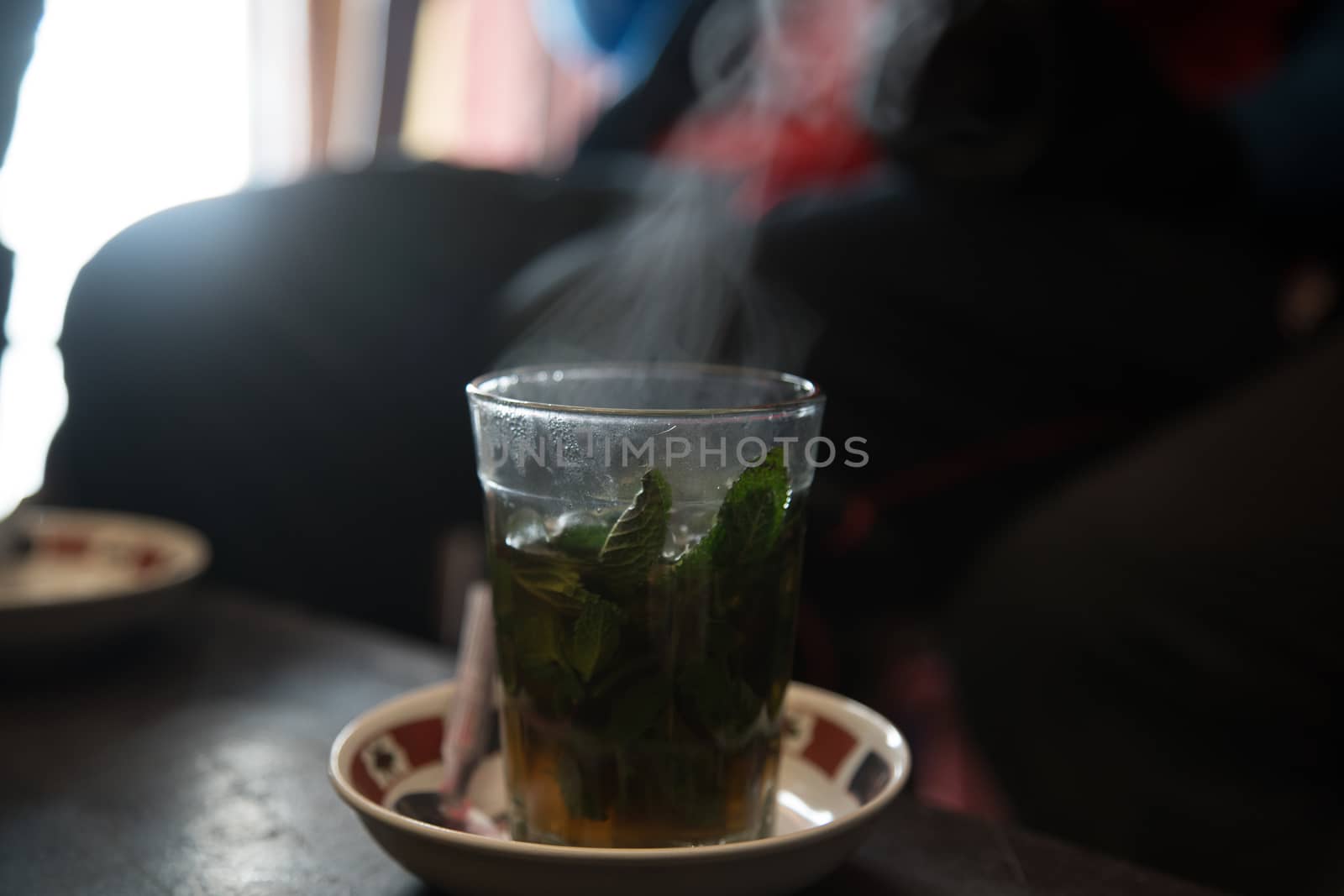 Hot bereber tea with smoke over a plate