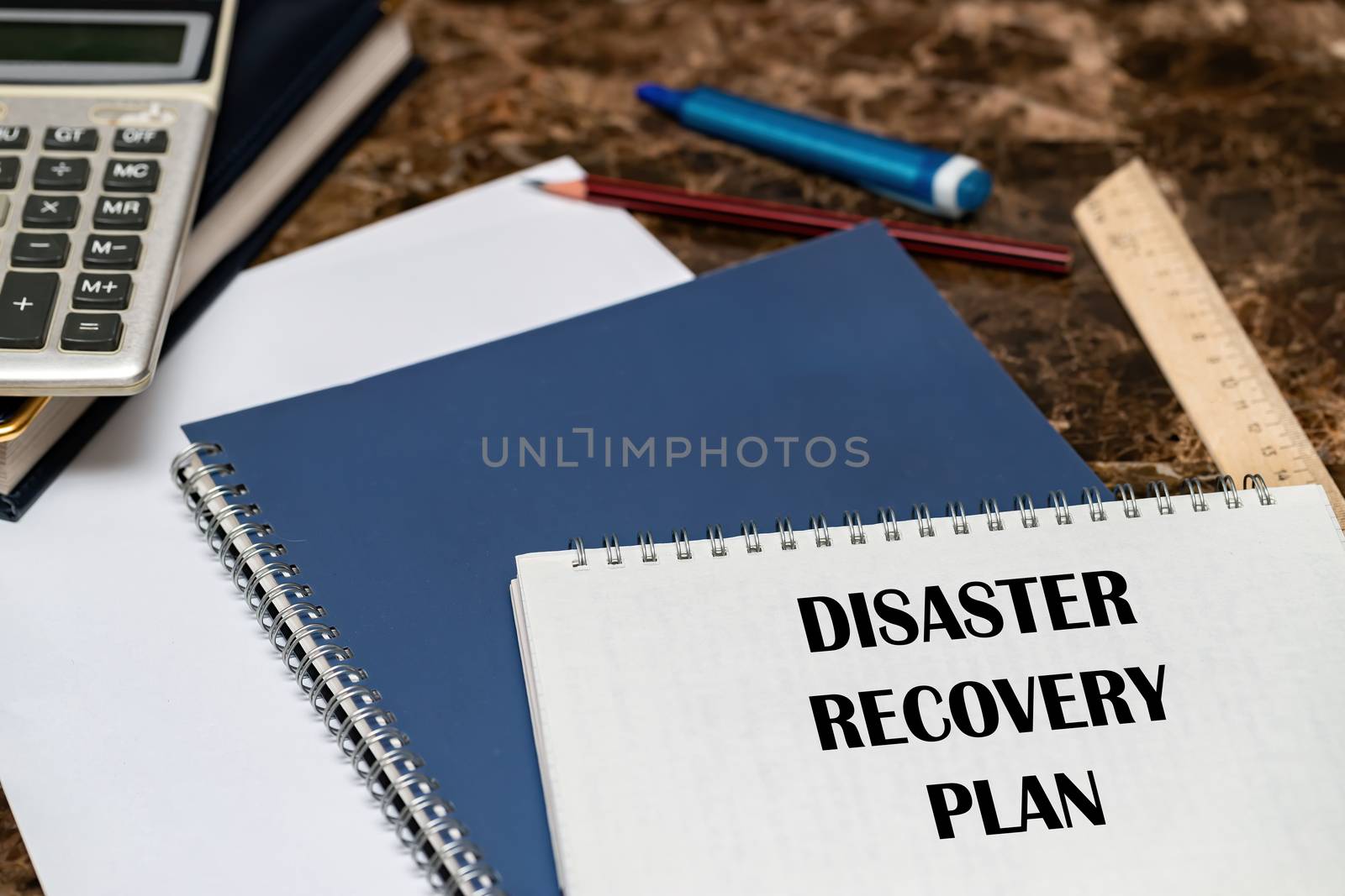 The text of the Disaster Recovery Plan is written on a white sheet lying on the office Desk.
