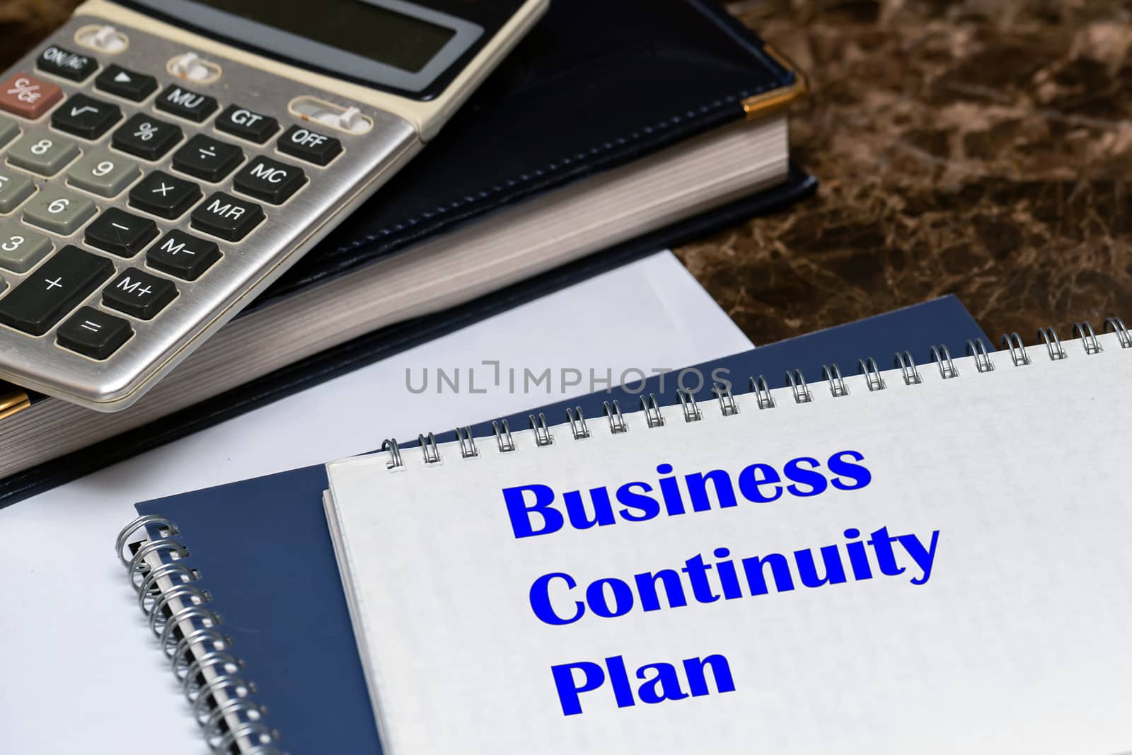 The text of the business continuity plan is written on a white sheet lying on the office Desk. by bonilook