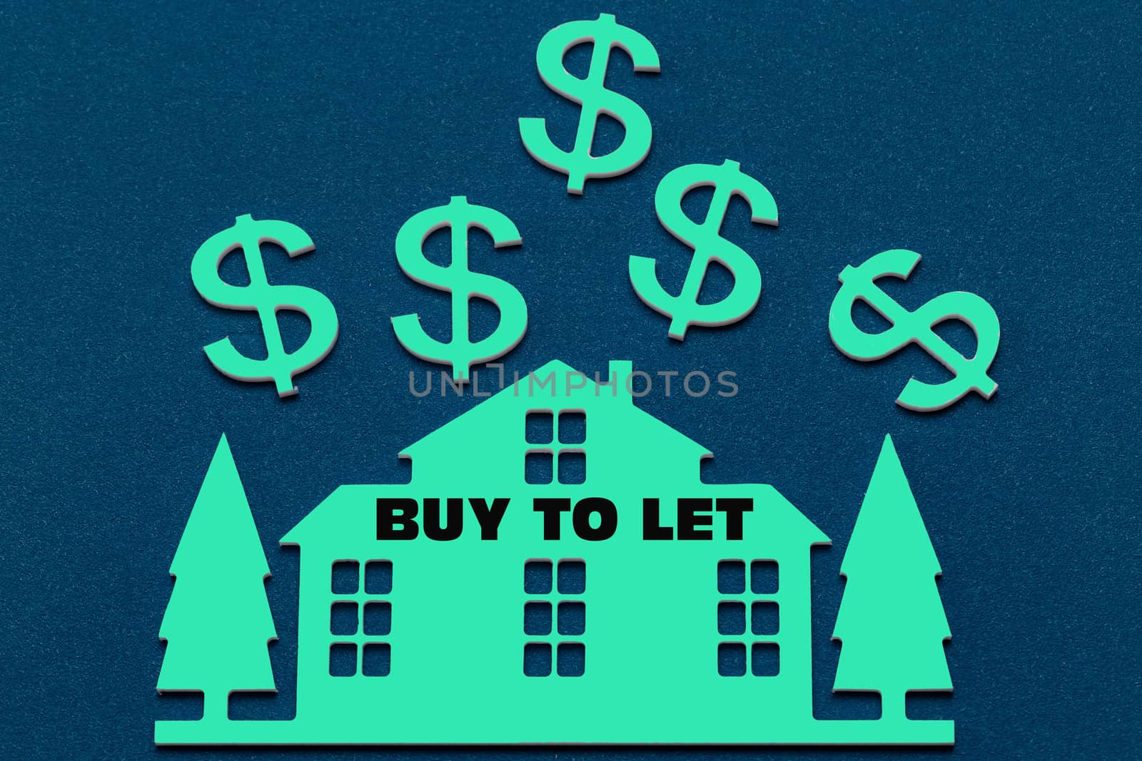 Miniature house on a blue paint background and text Buy To Let. Business, finance, saving money, property ladder or mortgage loan concept