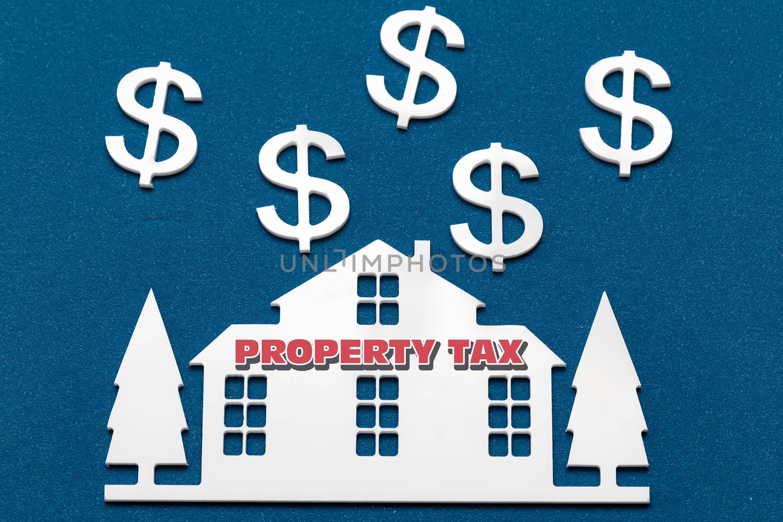 Miniature houses on a blue paint background and text Property Tax. Business, finance, saving money, property ladder or mortgage loan concept