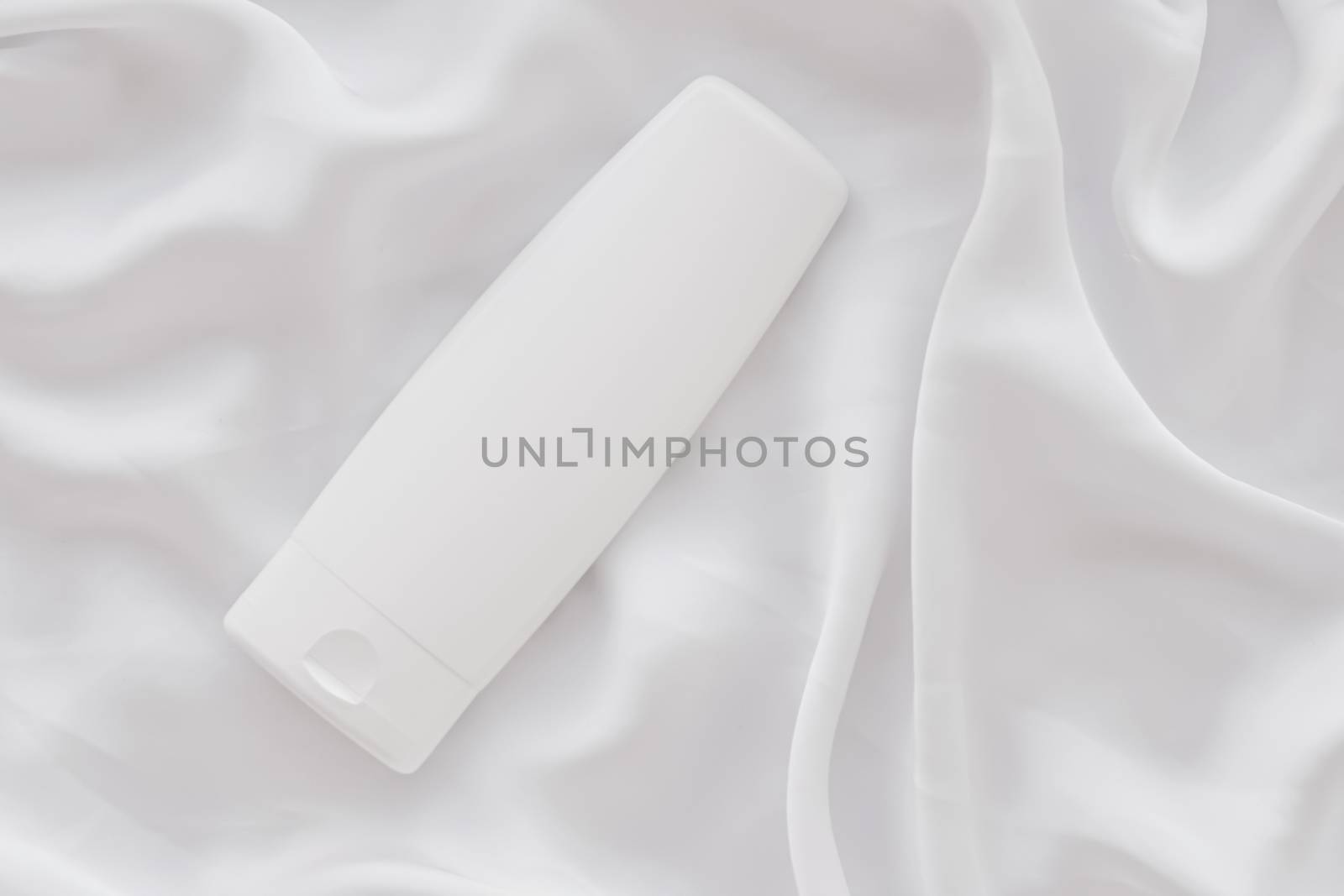 Blank label cosmetic container bottle as product mockup on white silk background, hygiene and healthcare