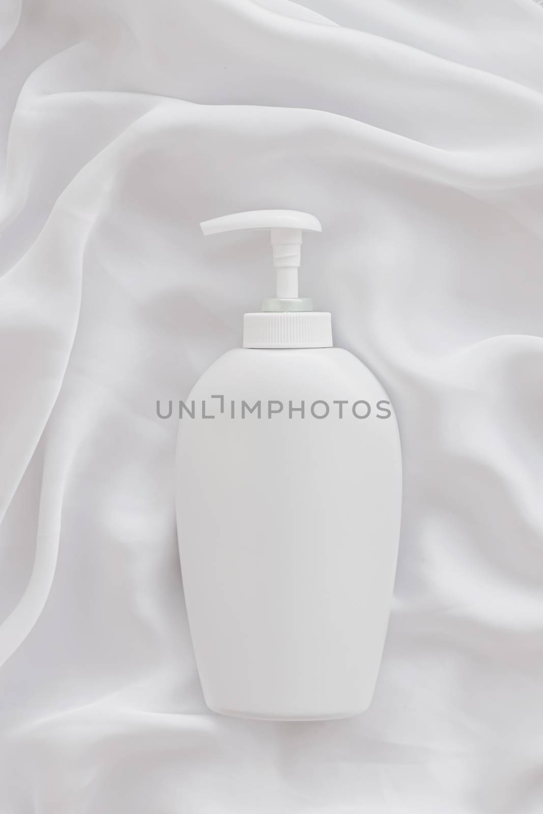 Blank label cosmetic container bottle as product mockup on white silk background by Anneleven