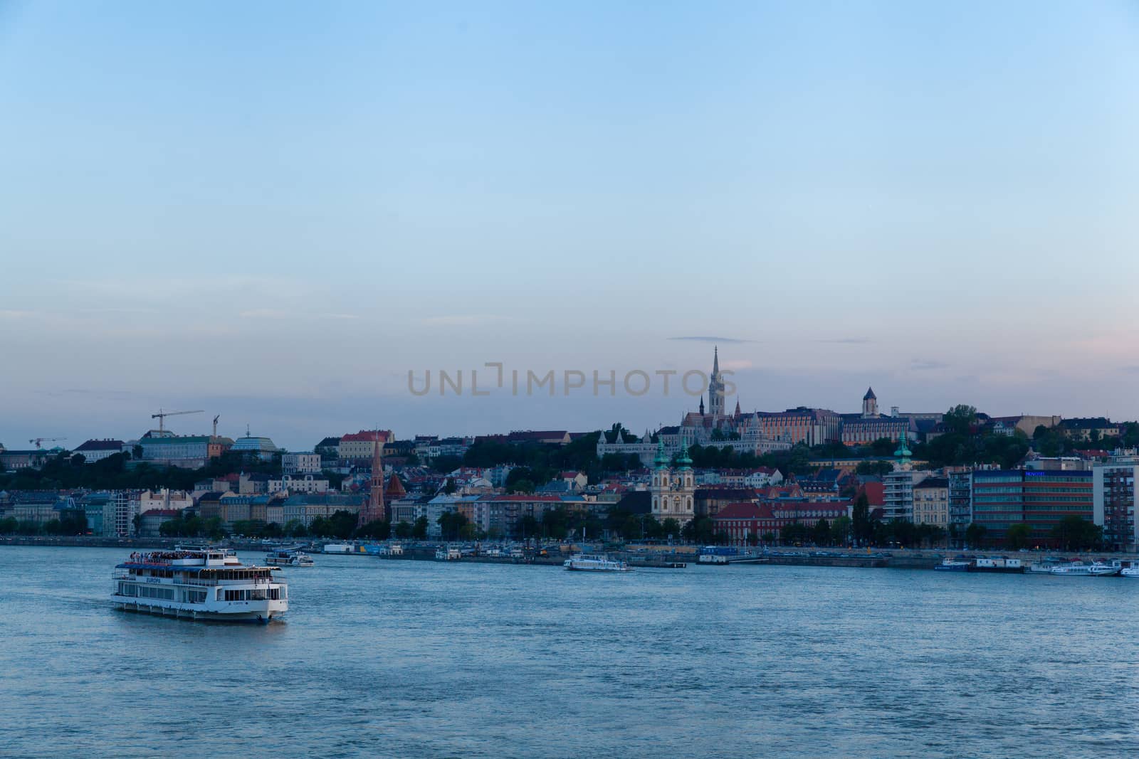 Budapest, Hungary - 4 May 2017: Buda view at sunset showing a pleasure boat, Fisherman's Bastion and Danube