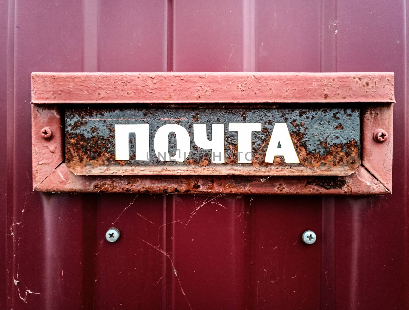 The inscription is mail. On a mailbox mounted in a fence.