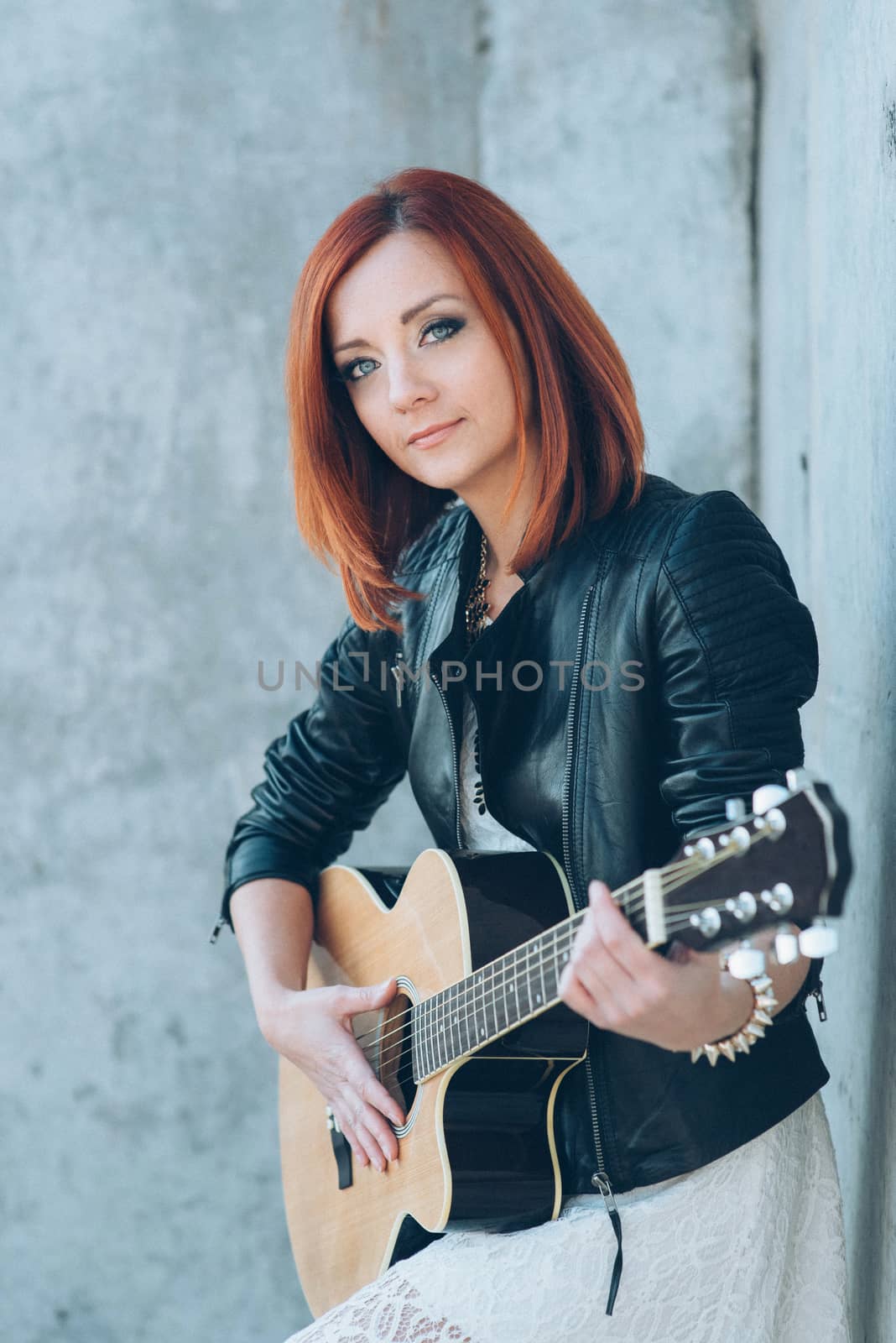 musician young girl with red hair with an acoustic guitar