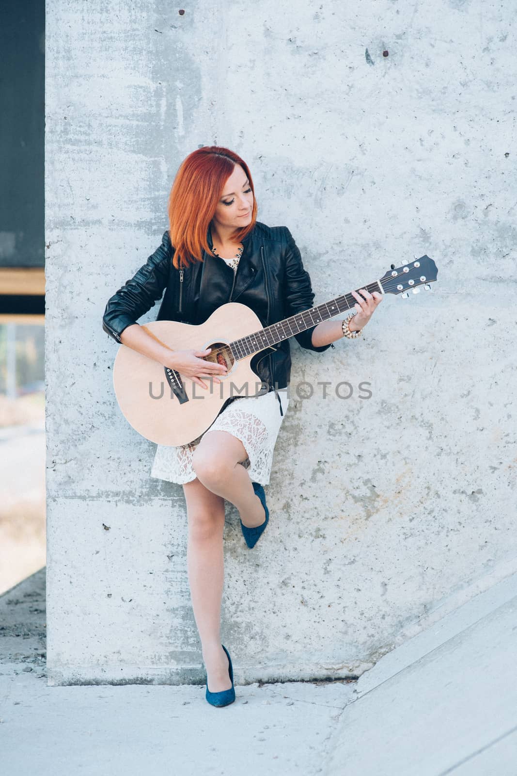 musician young girl with red hair with an acoustic guitar