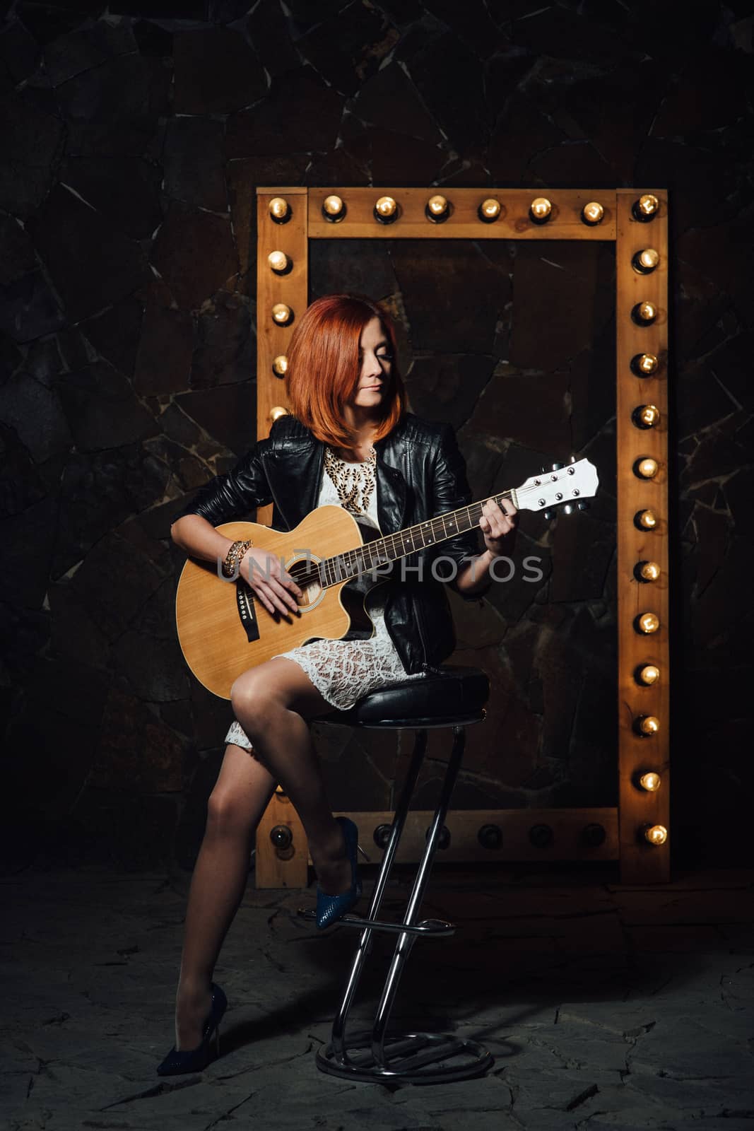 musician young girl with red hair with an acoustic guitar