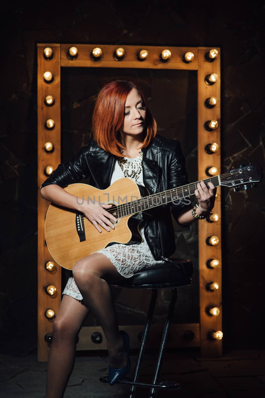 musician young girl with red hair with an acoustic guitar