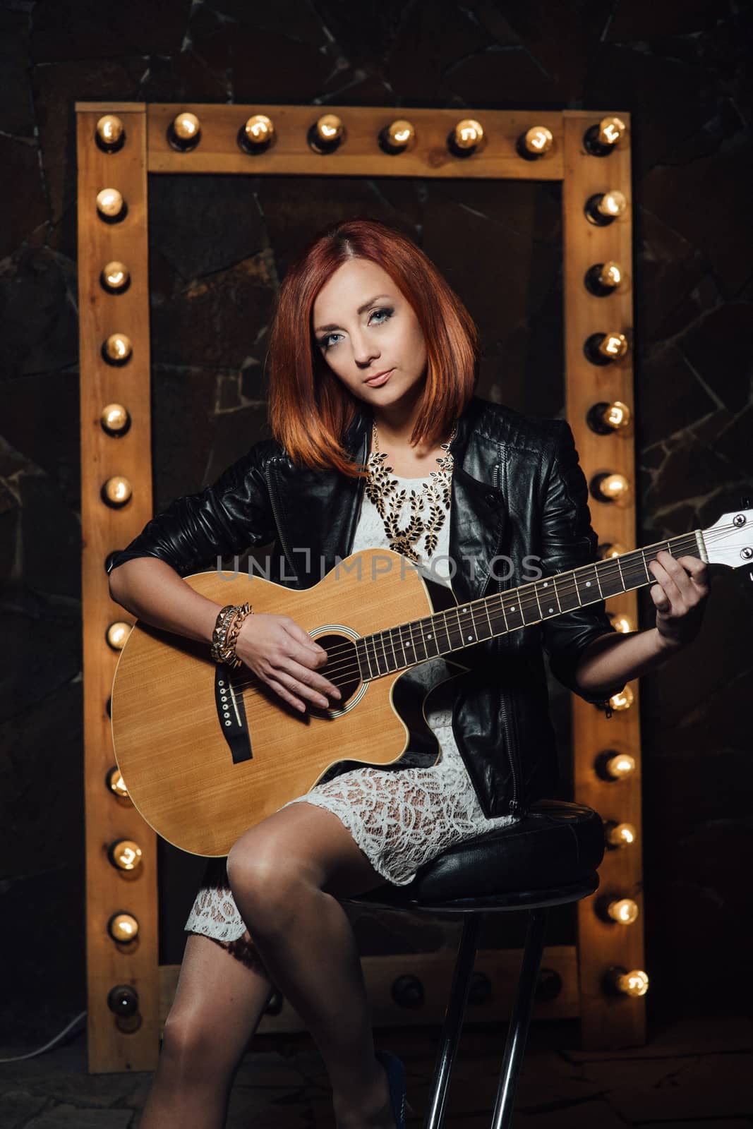 musician young girl with red hair with an acoustic guitar