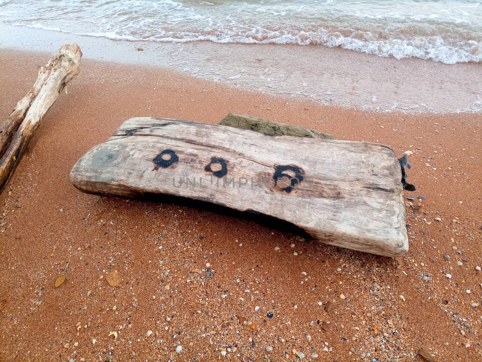 A large wooden log on the beach.