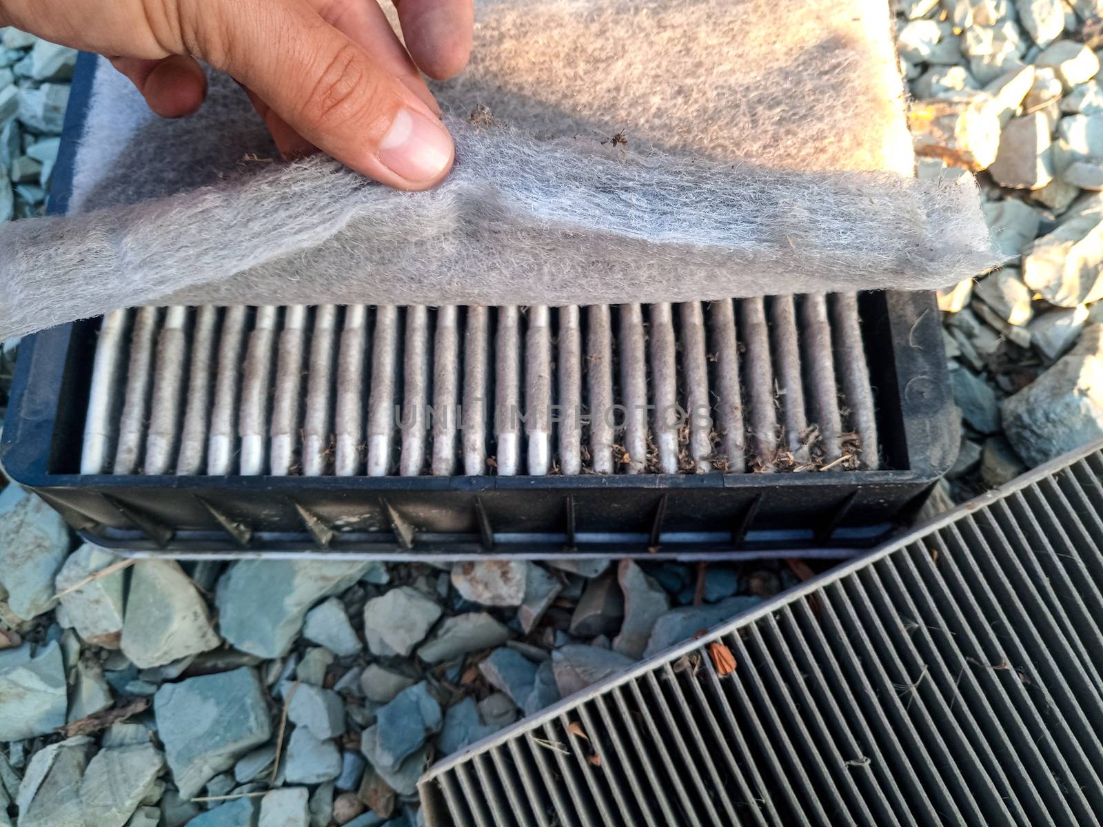 An old dirty filter out of the car. Replacing the air filter.