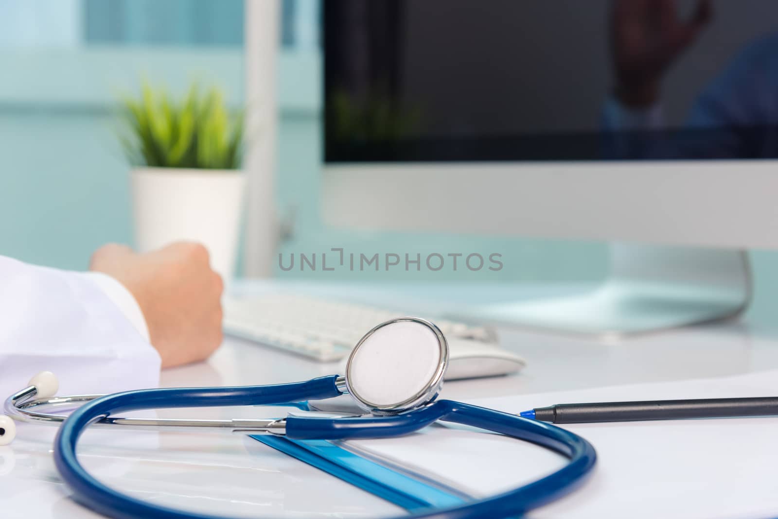 Medicine doctor's working on desk. Closeup of Stethoscope. Hand of man physician video call raise hands to greet patients on table front computer monitor at hospital office, Healthcare medic concept