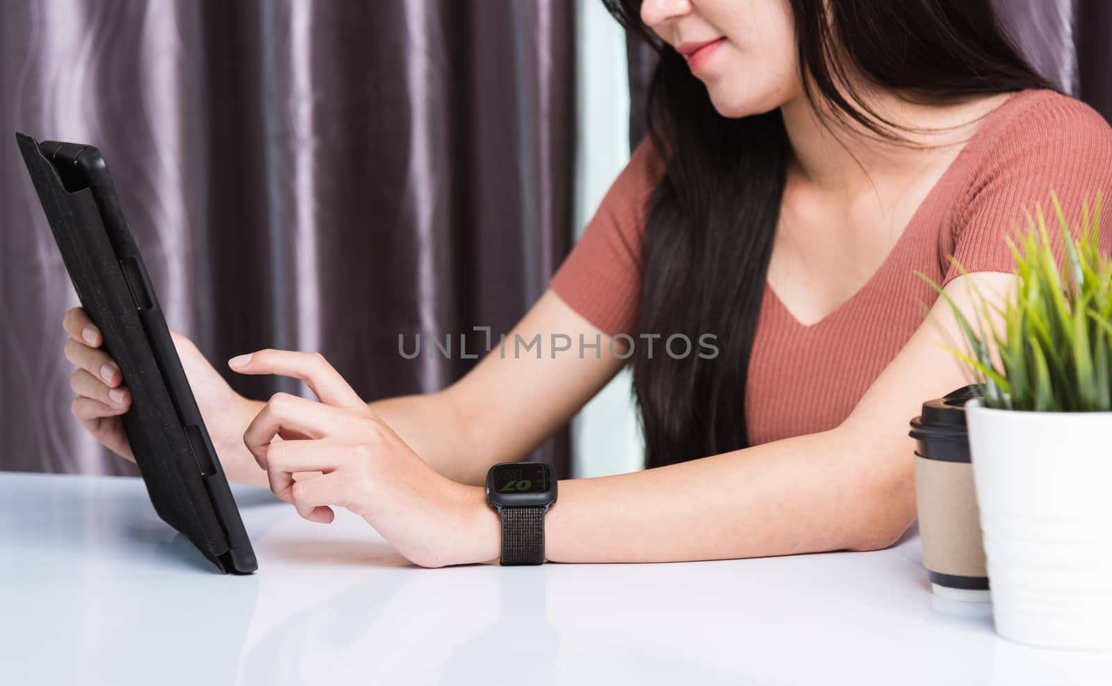 Work from home, Happy Asian business young beautiful woman sitting on desk workspace video call conferencing, write, check or read mail on digital tablet computer technology at home office