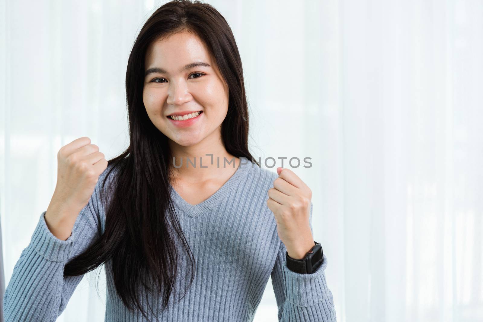 Beautiful woman smiling face long hair raise hand make success o by Sorapop