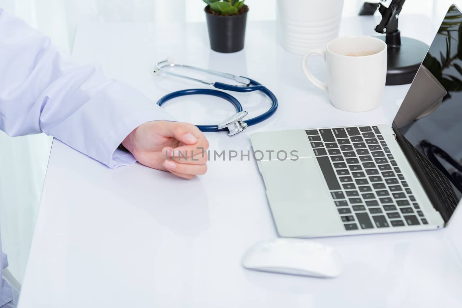 Medicine doctor's working on desk. Closeup of Stethoscope. Hand of Asian woman physician explain to patients on table front laptop computer at the hospital office, Healthcare medic concept