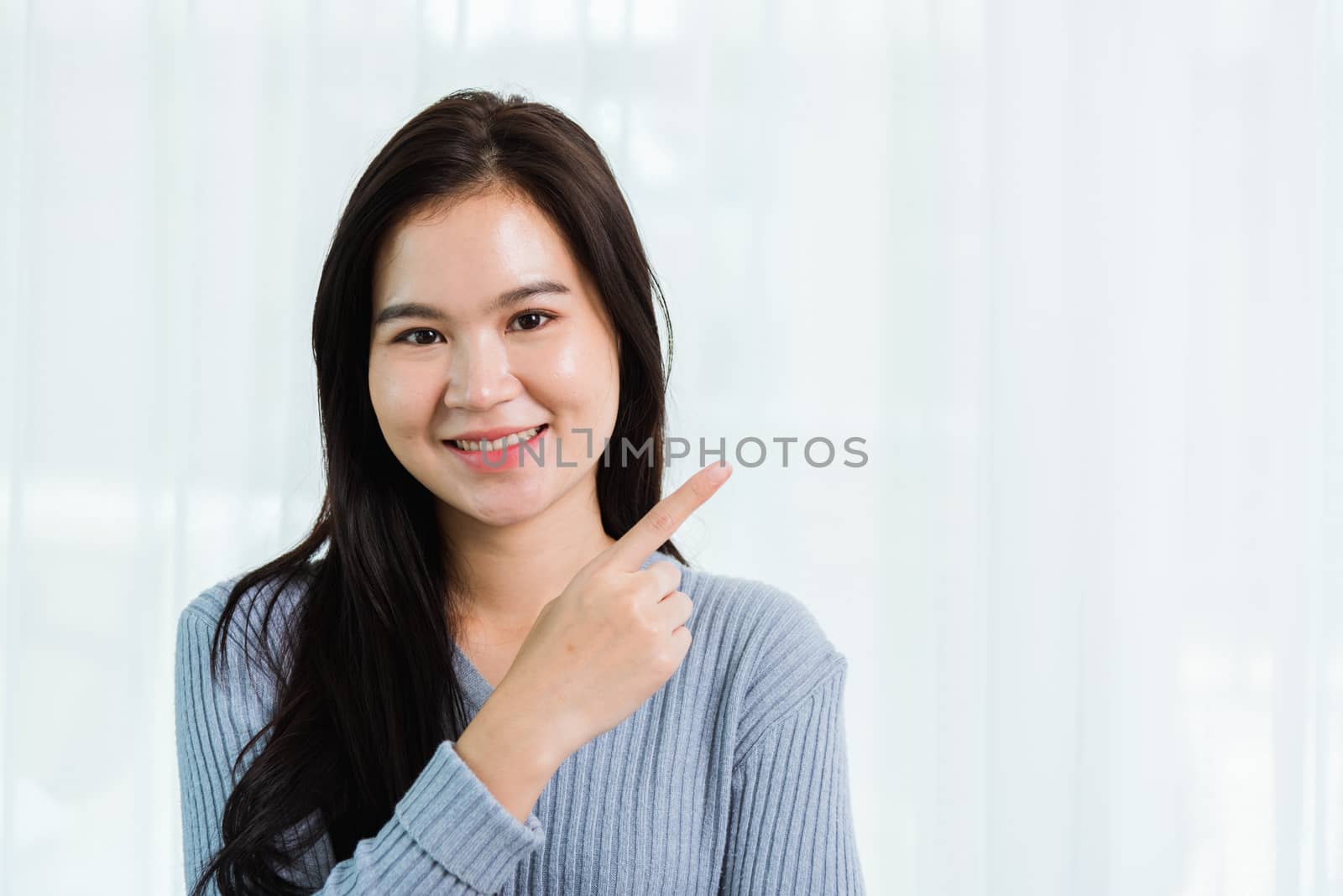 Asian beautiful woman smiling face long hair stand pointing fing by Sorapop