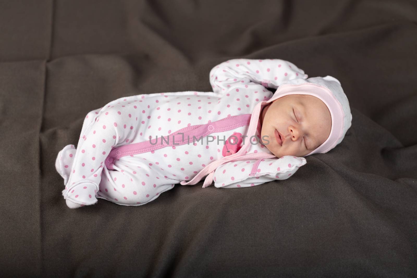 Little newborn baby boy sleeps in darck background.