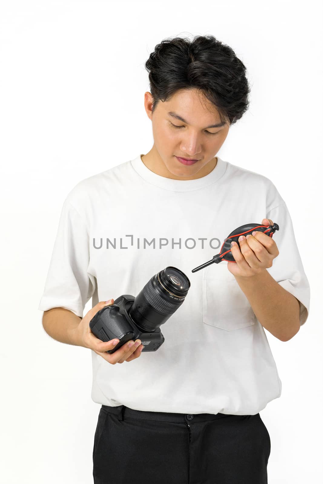 An Asian photographer is cleaning the camera and lens with a air blower camera cleaning for shooting fashion models in the studio.