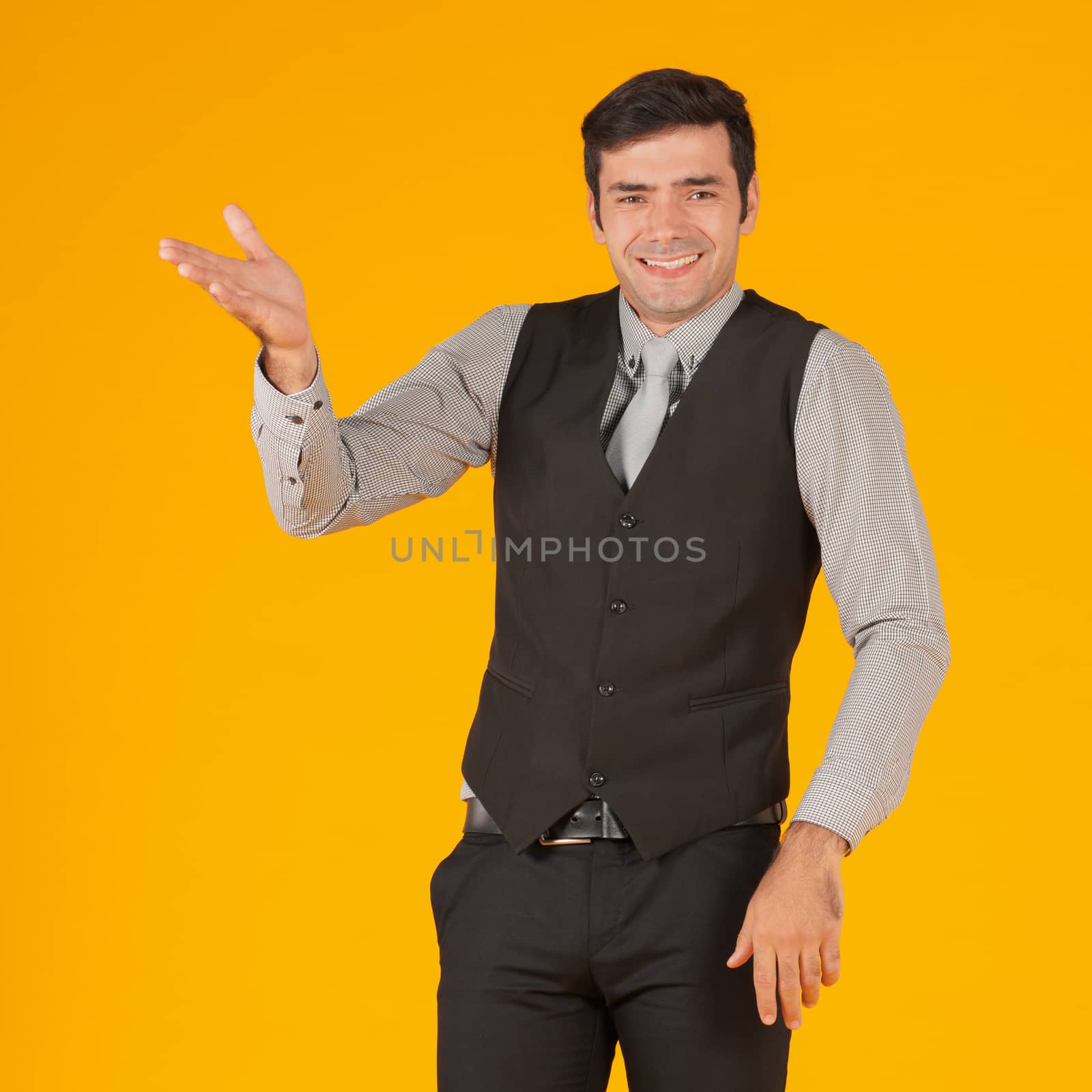 A young businessman in a black vest raises his hand with a surprised expression after hearing news about his business investment.