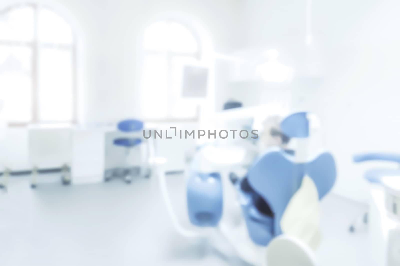 Blurred background of a dentist office with a patient on a chair ( copy space)