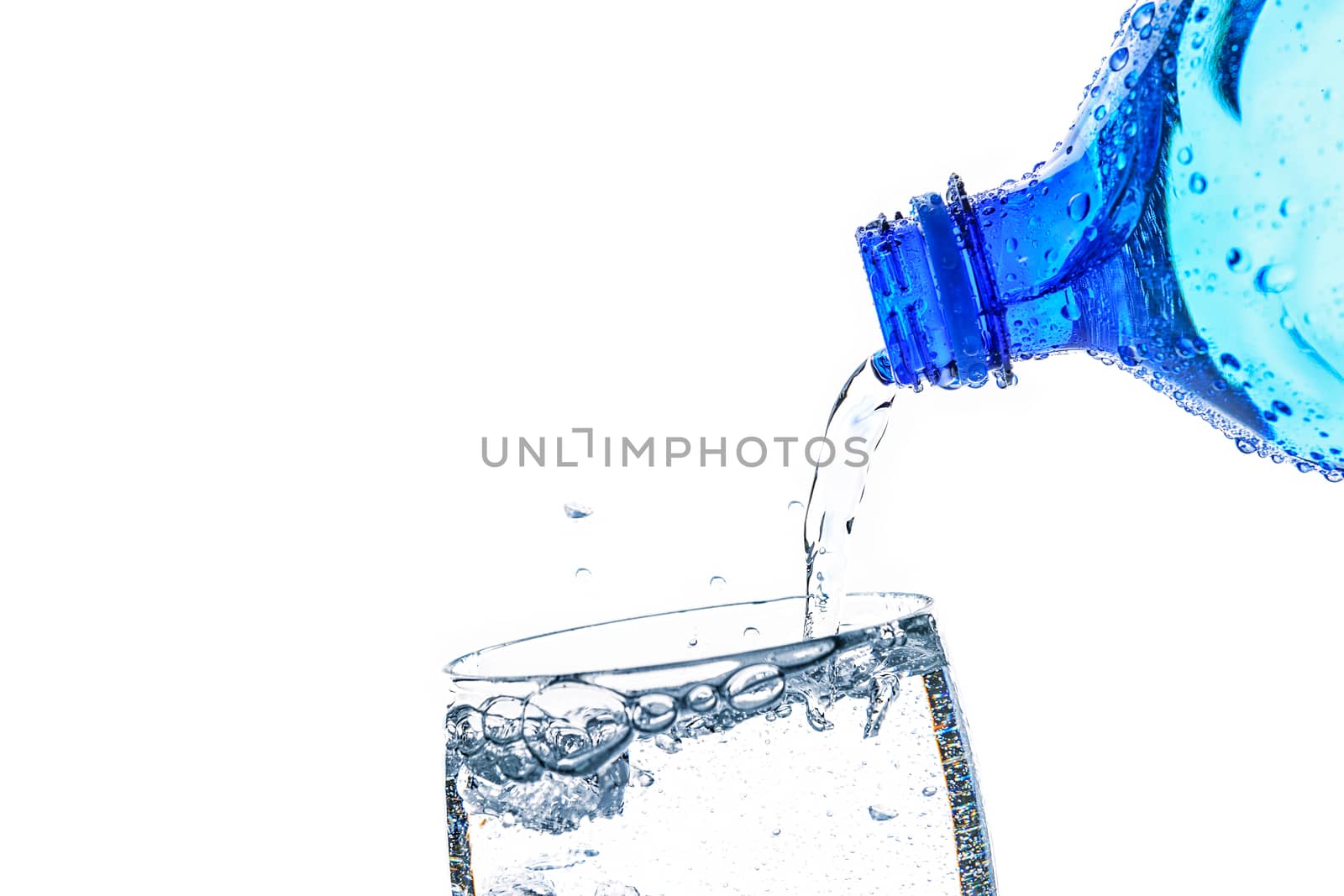 Fresh mineral water is poured into a glass with a splash on a white background in close-up (copy space for add text)