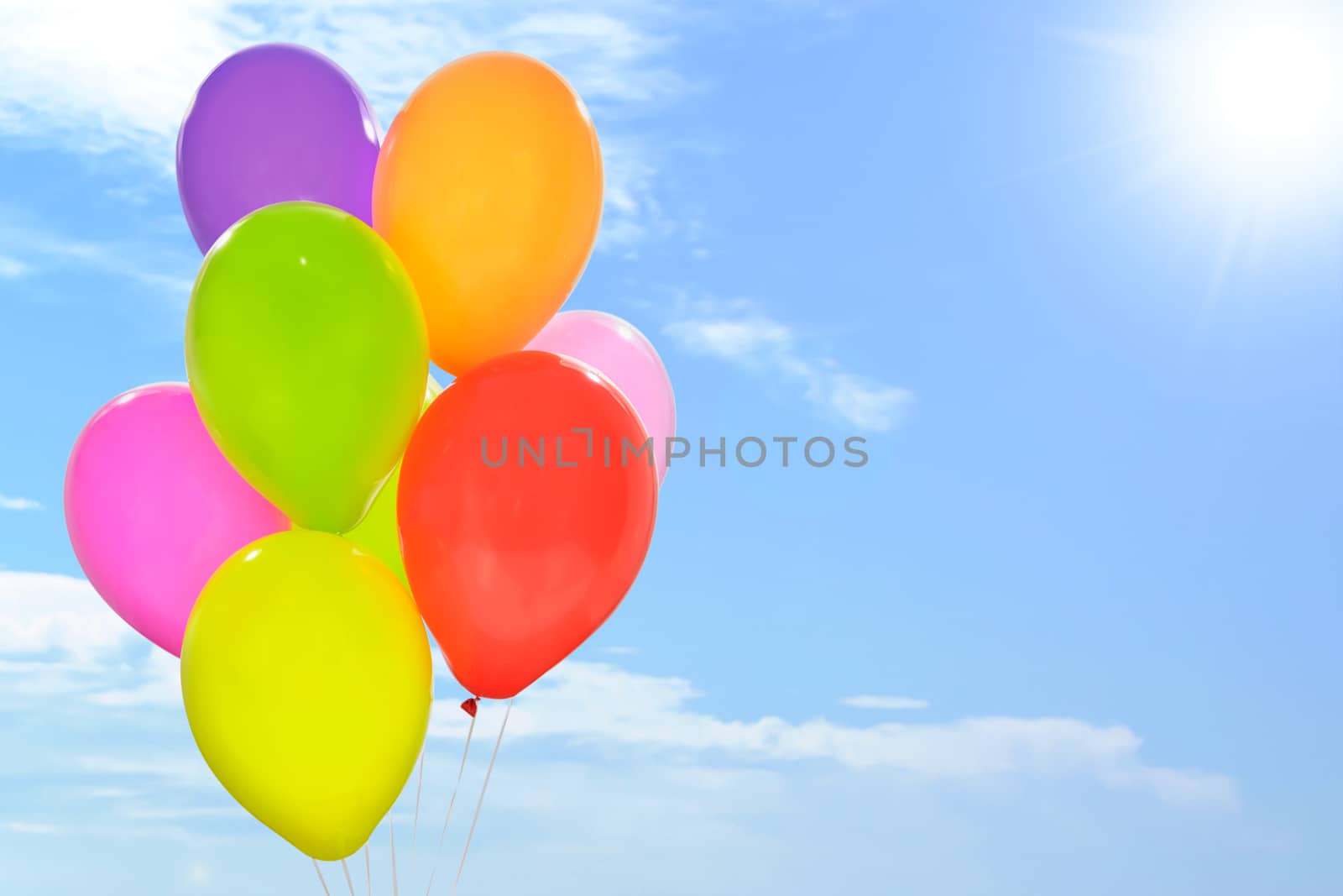 Party decoration concept - mix of colorful balloons on a blue sky background with copy space (mixed).