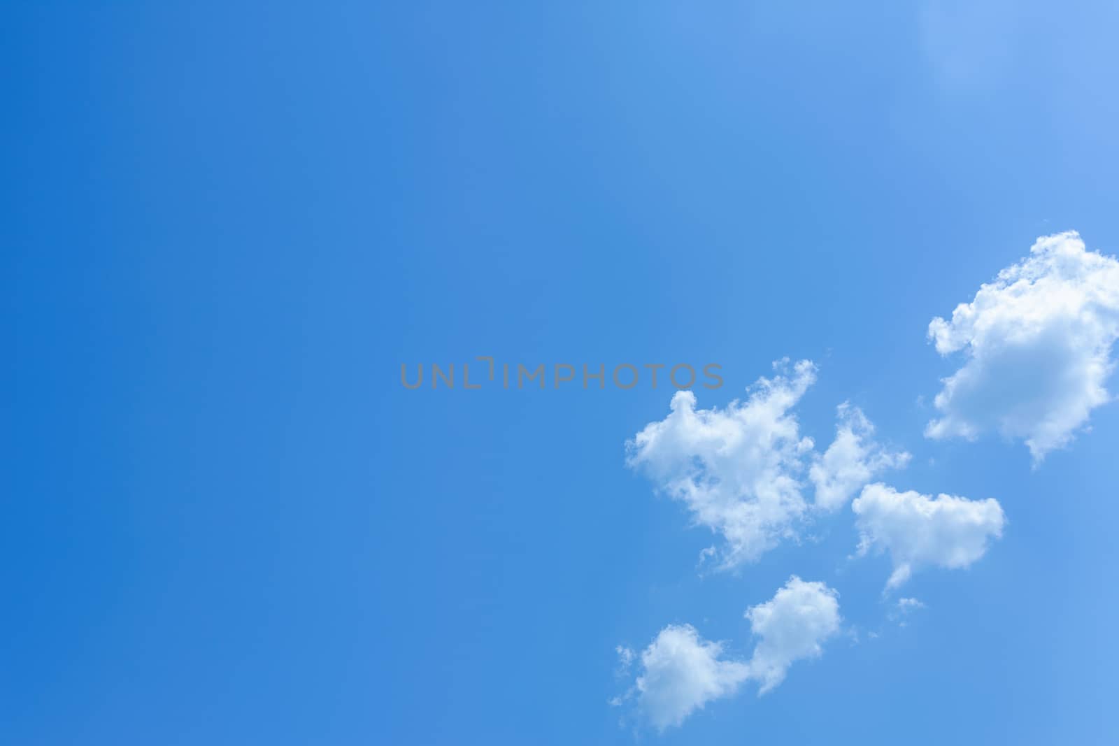 Blue sky background with tiny white clouds.