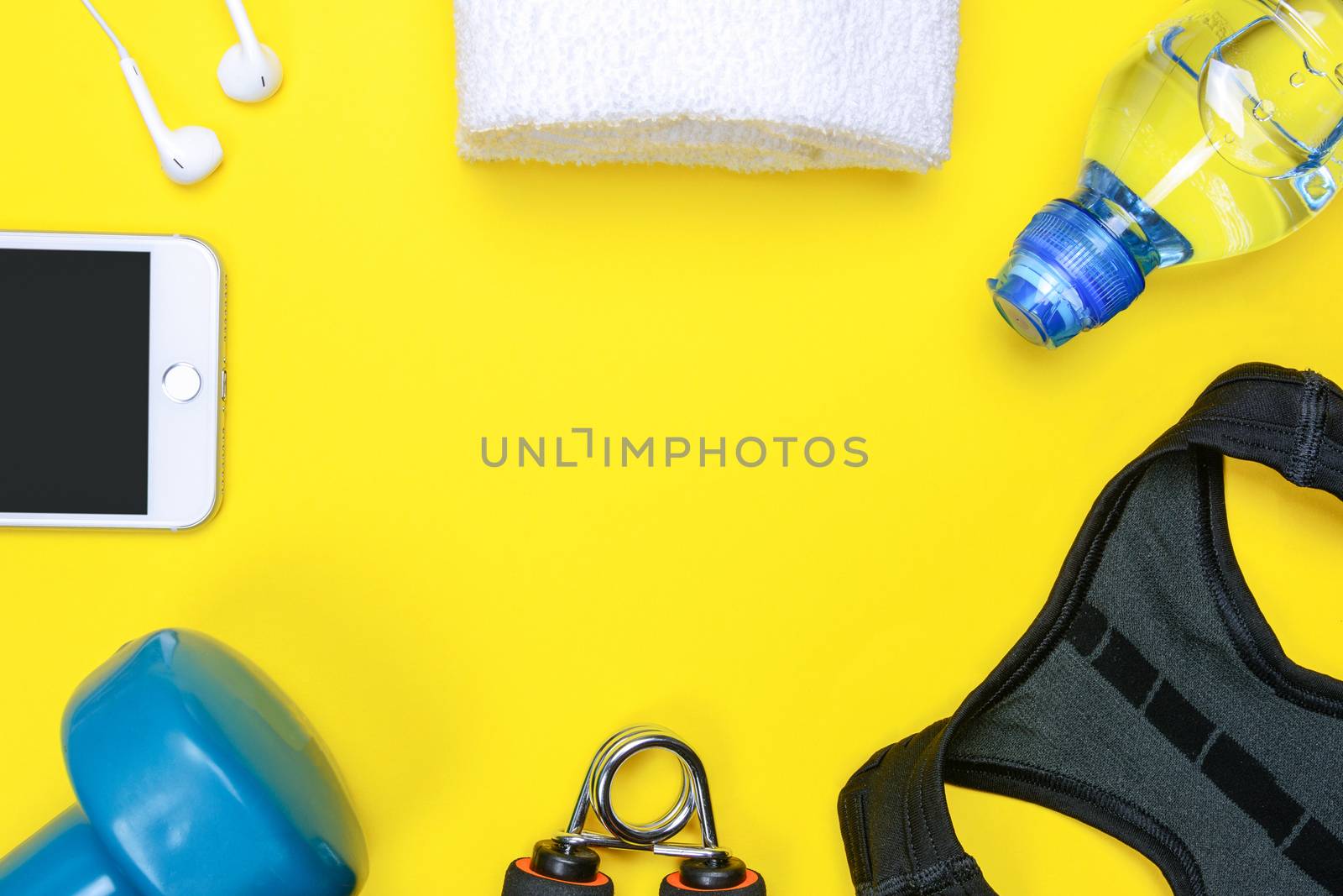 Fitness activity concept - flat lay of some personal sport accessories for woman on a yellow background with copy space.