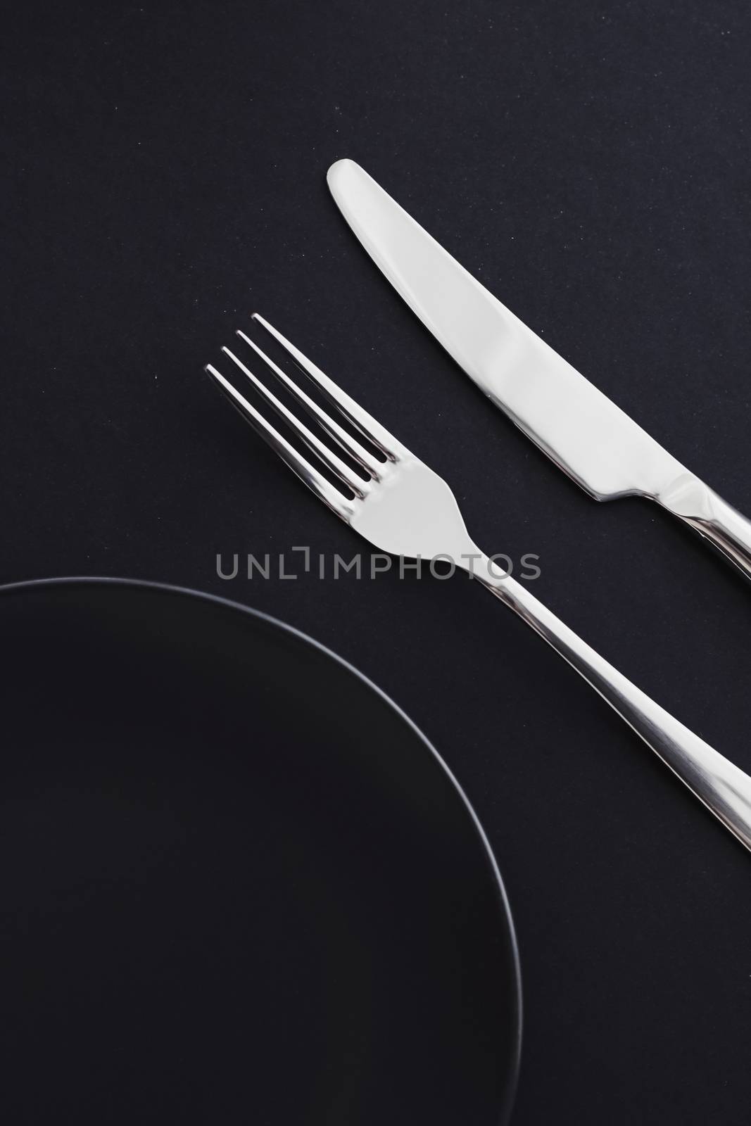 Empty plates and silverware on black background, premium tableware for holiday dinner, minimalistic design and diet by Anneleven