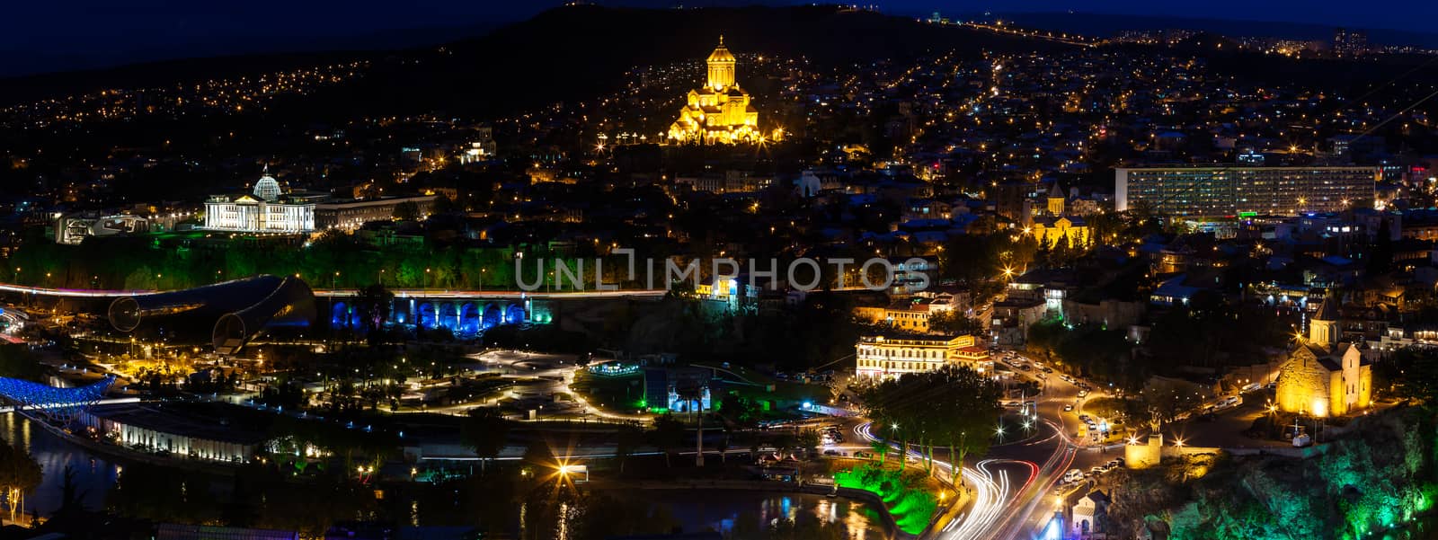 Night panorama view of Tbilisi, capital of Georgia country. Metekhi church, Holy Trinity Cathedral (Sameba) and Presidential Administration at night with illumination and moving cars.