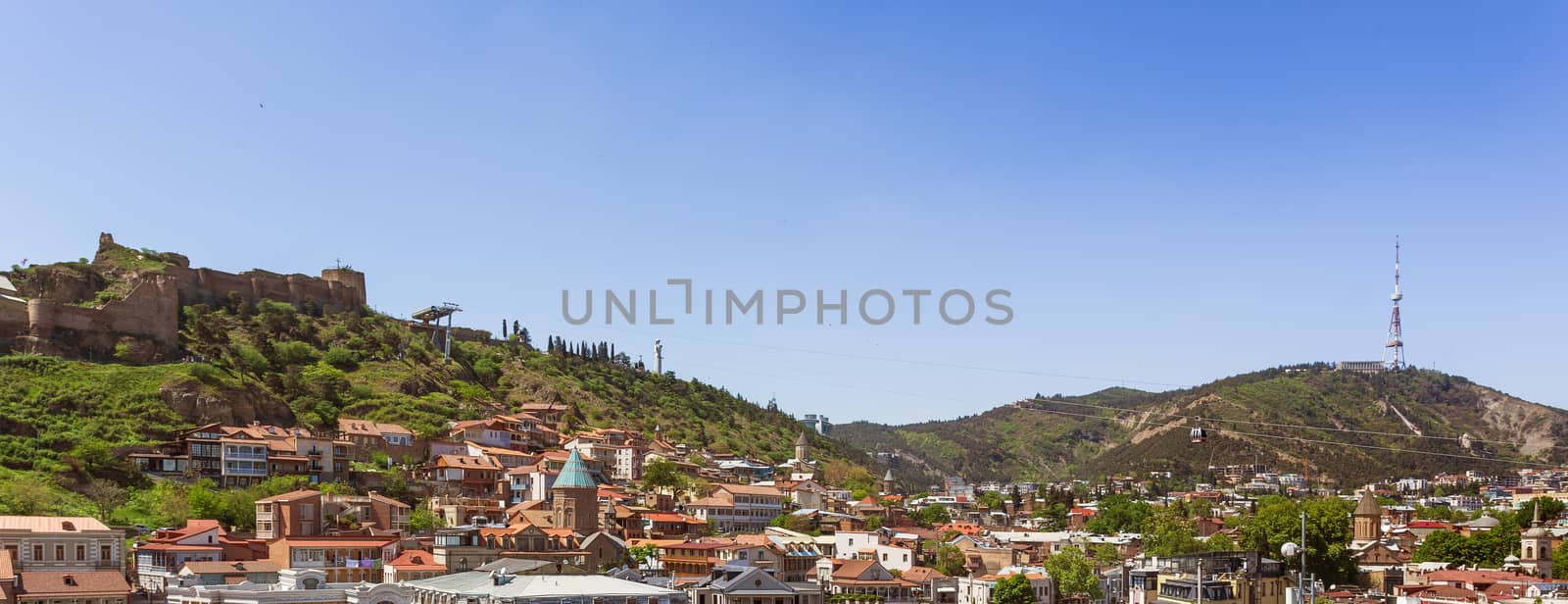 Panorama view of old part of Tbilisi, Narikala fortress, cable road above tiled roofs. Georgia country.