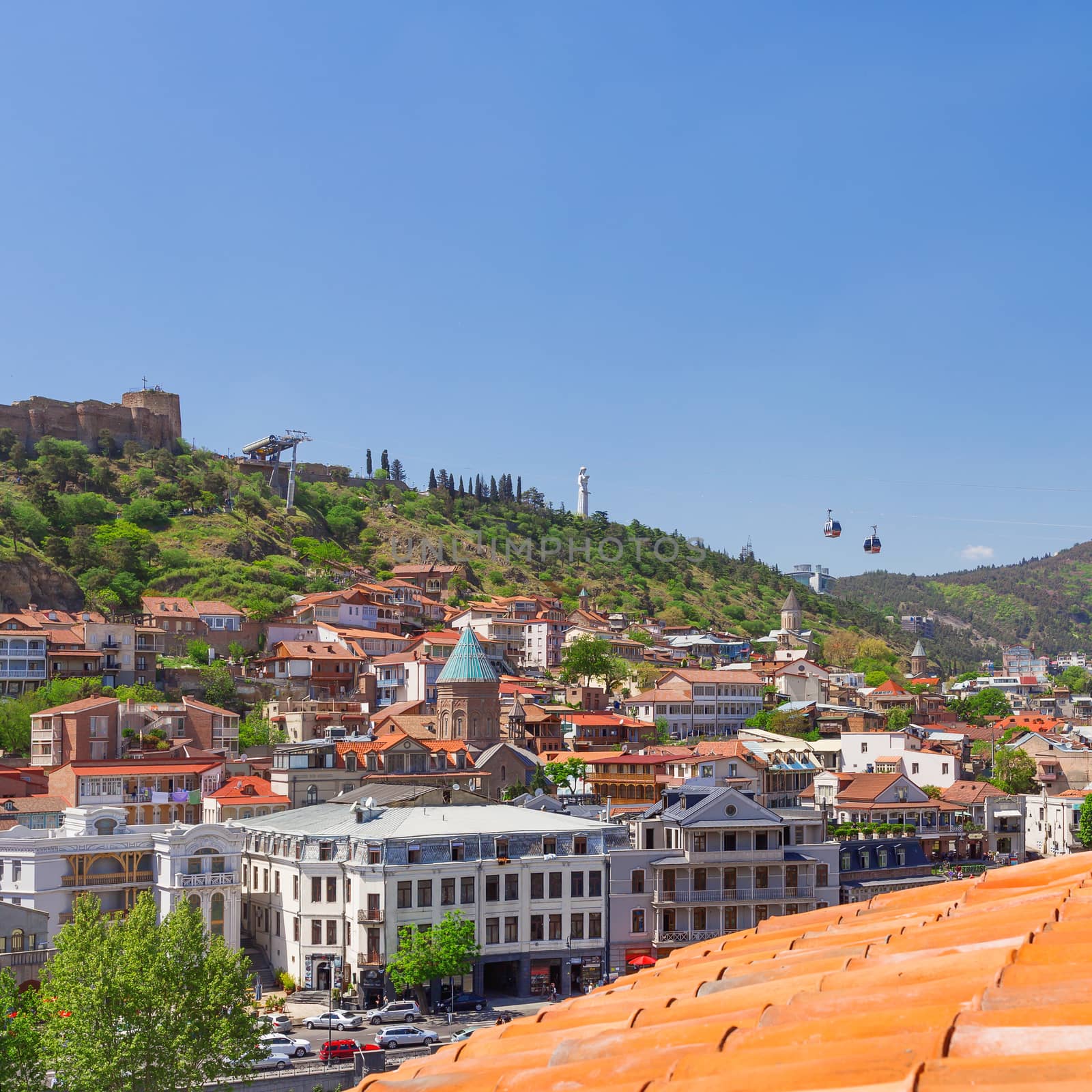 Tbilisi, old part of town with cafe, little restaurants, cobbled pavement and antique buildings. Cathedral of Saint George (Surb Gevorg) in the historical quarter. Georgia. by aksenovko