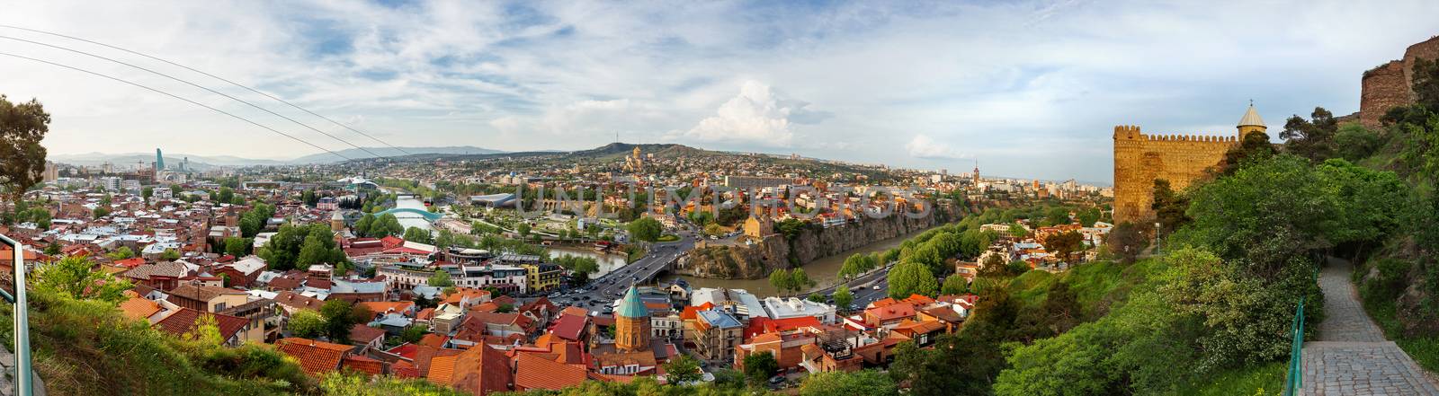 Large panorama view of Tbilisi, capital of Georgia country. View from Narikala fortress. Cable road above tiled roofs. by aksenovko