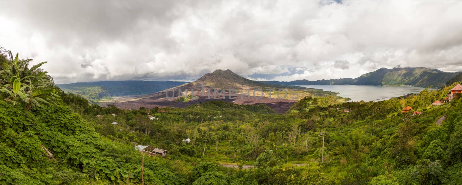 Volcano Batur, panorama view from Kintamani. Volcano landscape view with forest in cloudy day of winter rainy season. Bali, Indonesia by aksenovko