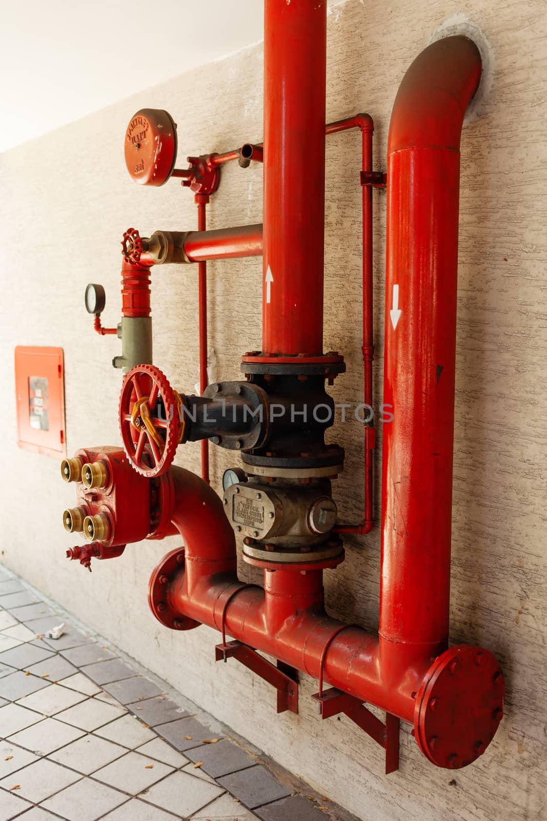 Red pipes on wall. Sprinkler alarm. Outdoor industrial equipment, Kuala Lumpur, Malaysia.