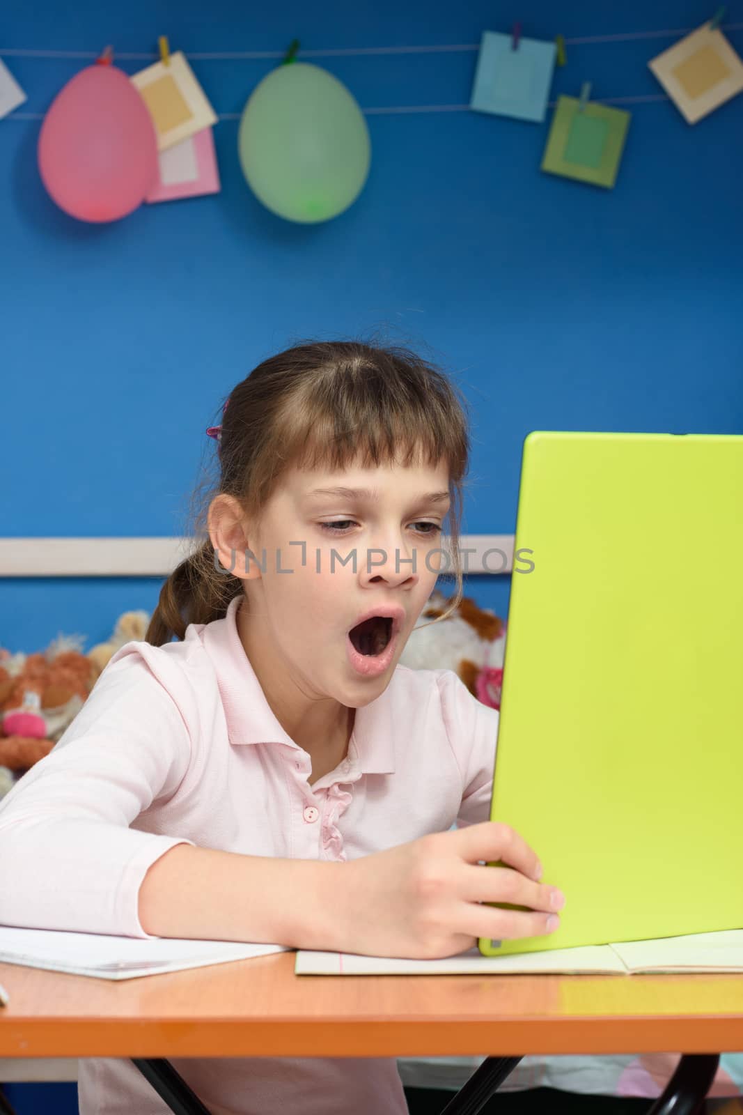 Girl yawns and watches video tutorials on a tablet