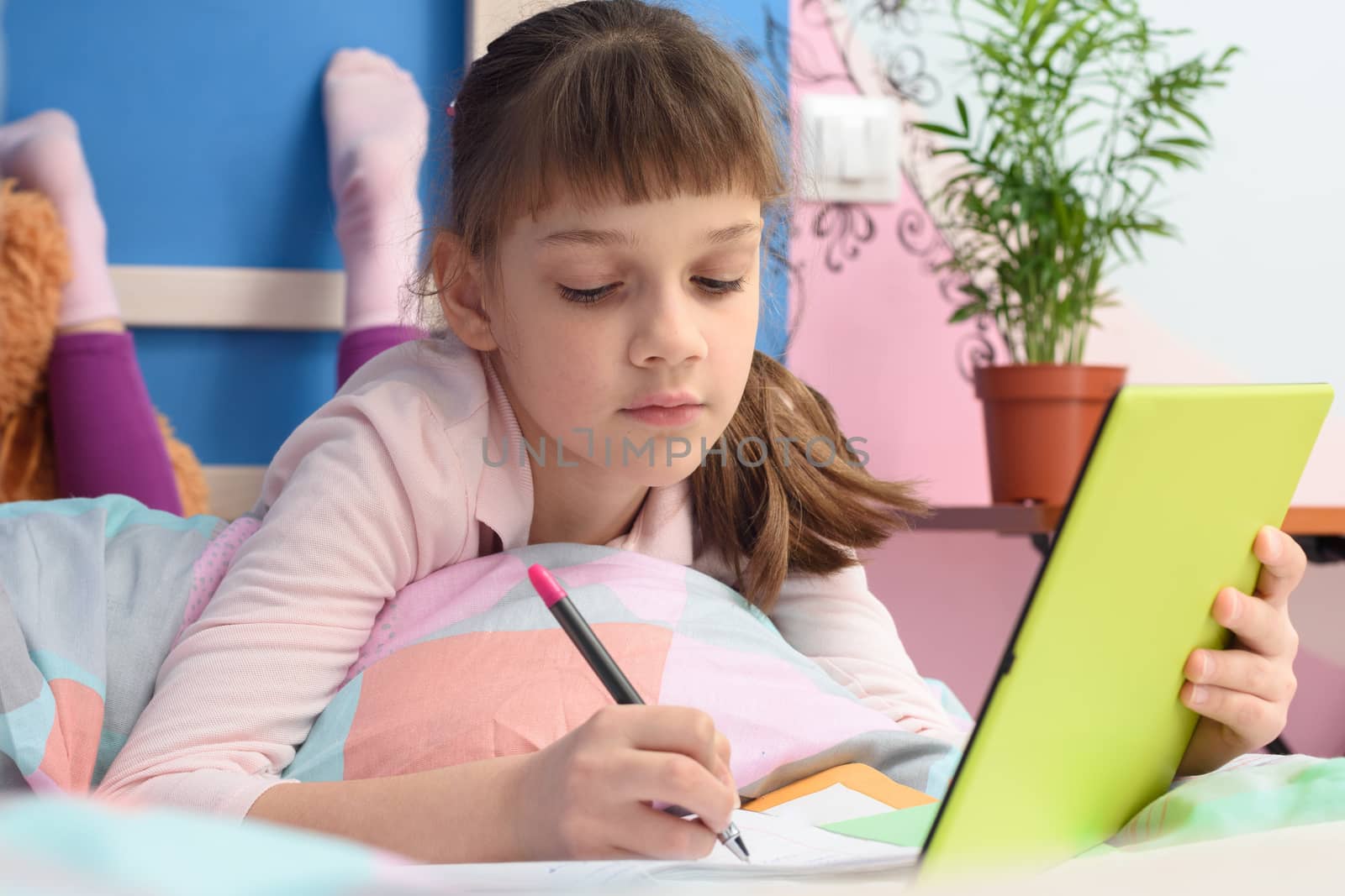 Student in her bed at home studying at school online