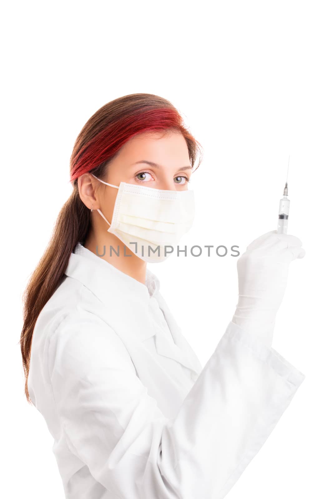 Beautiful young female doctor with protective surgical mask, holding a syringe with a needle, isolated on white background. Healthcare and vaccination concept.