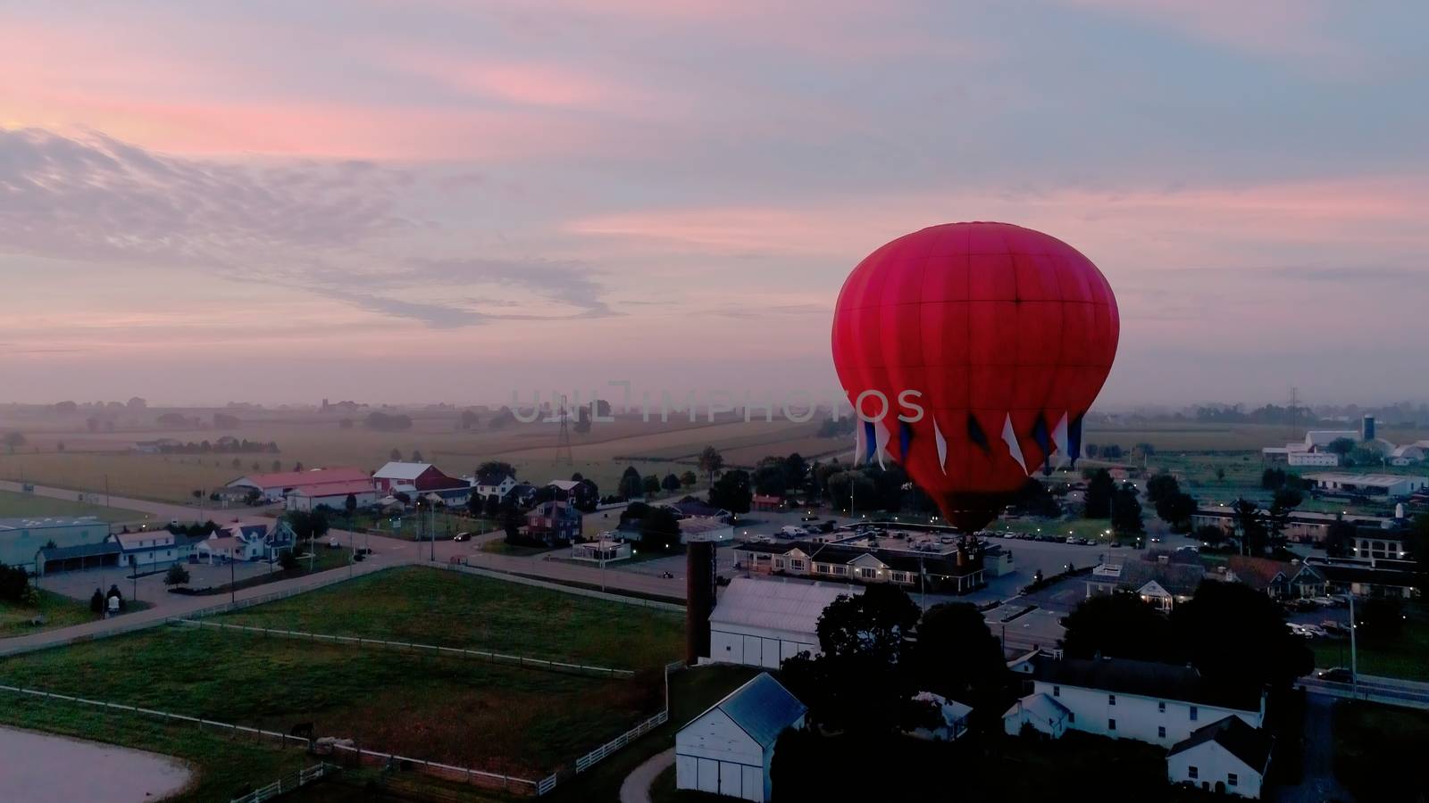 Aerial View of Sunrise with Hot air Balloons Taking Off with Glow as Seen by a Drone