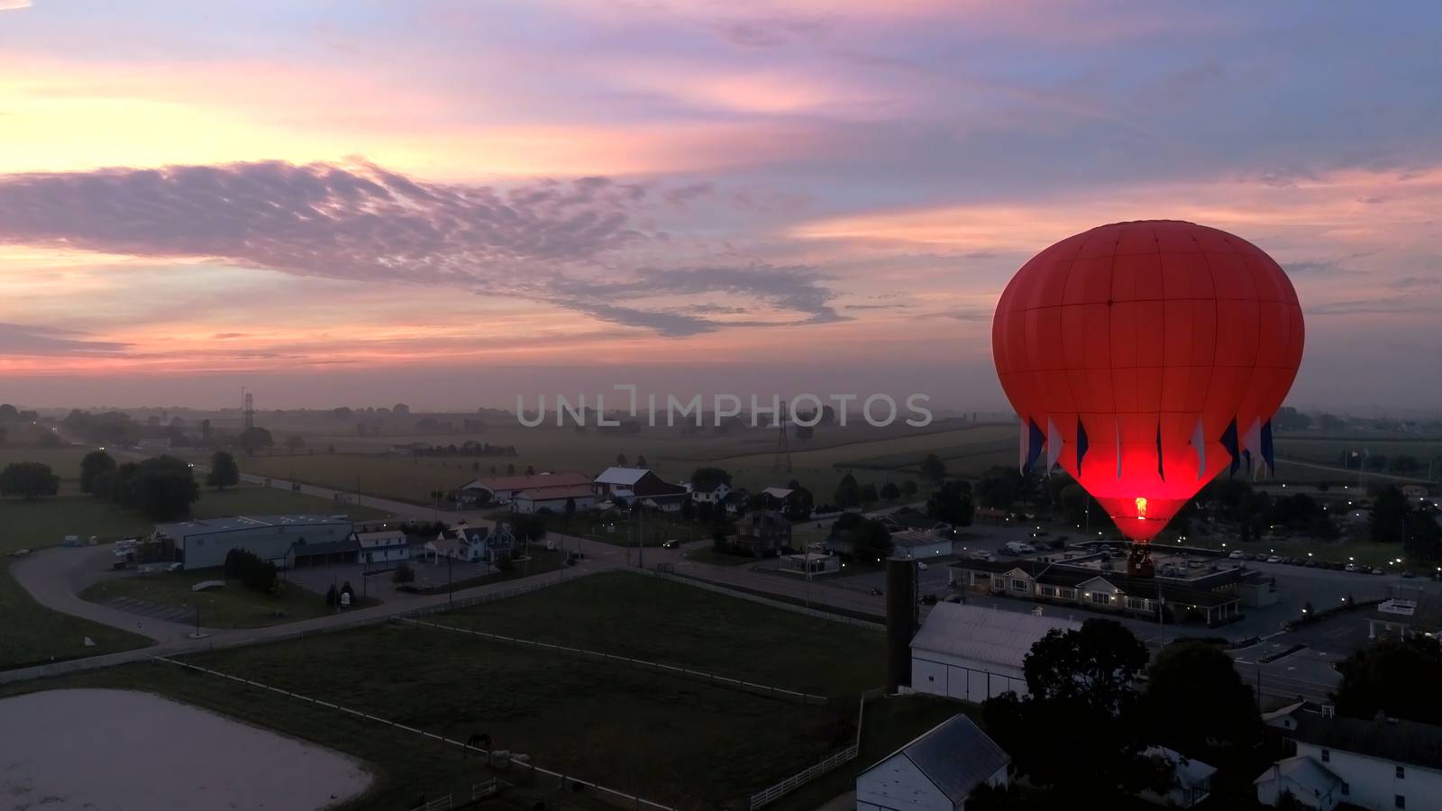 Aerial View of Sunrise with Hot air Balloons Taking Off with Glow as Seen by a Drone