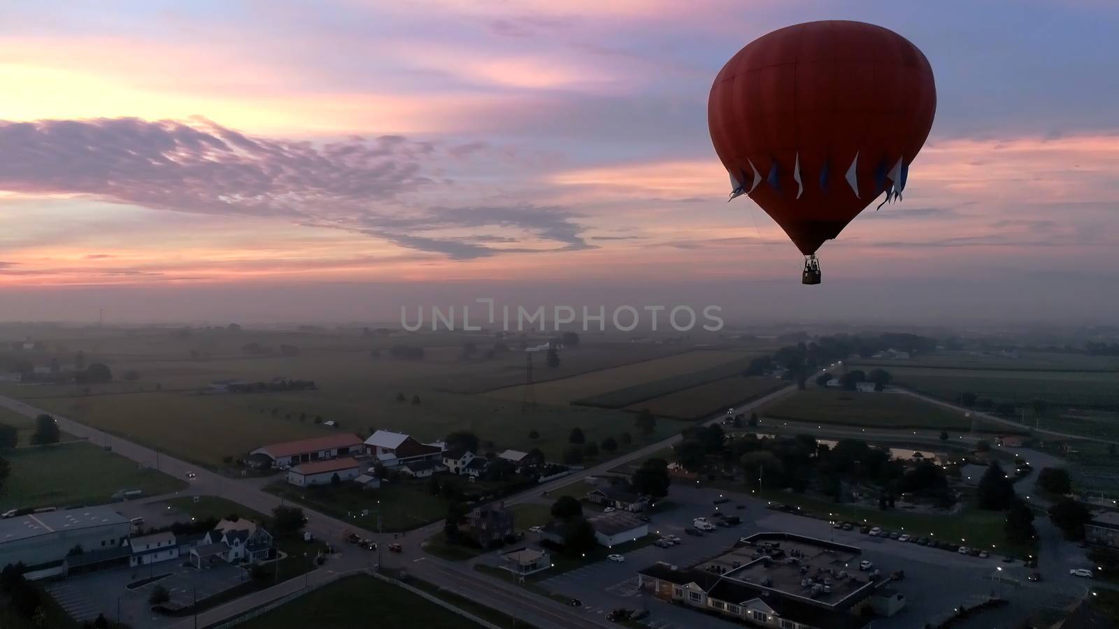 Aerial View of Sunrise with Hot air Balloons Taking Off with Glow as Seen by a Drone