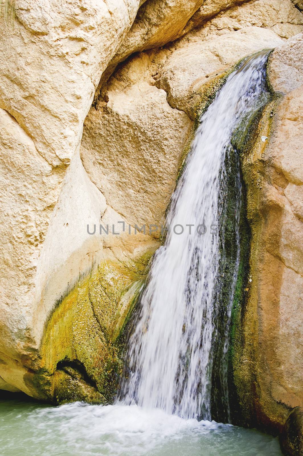 Waterfall among the rocks of oasis Chebika, famous landmark in Sahara desert.